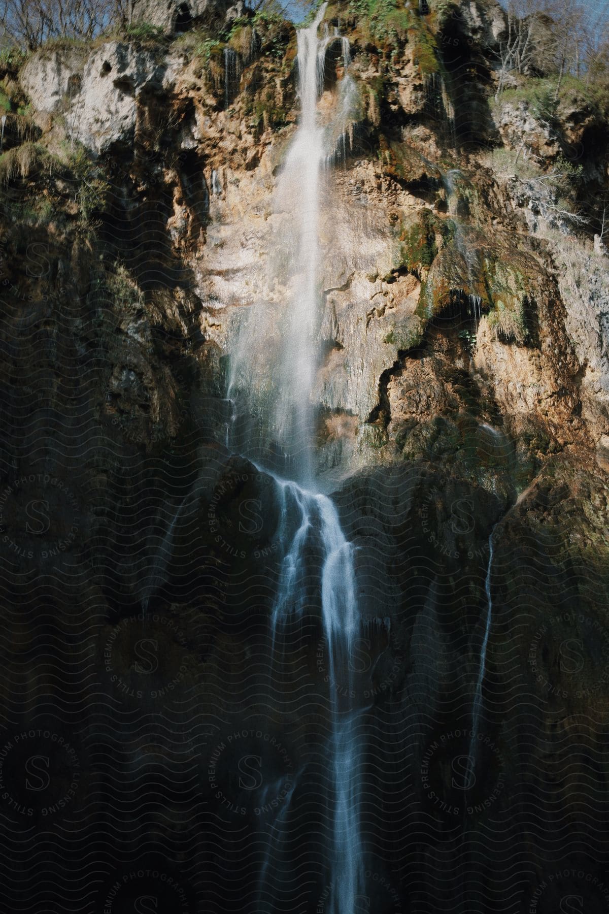 Waterfalls flow over the side of a steep cliff