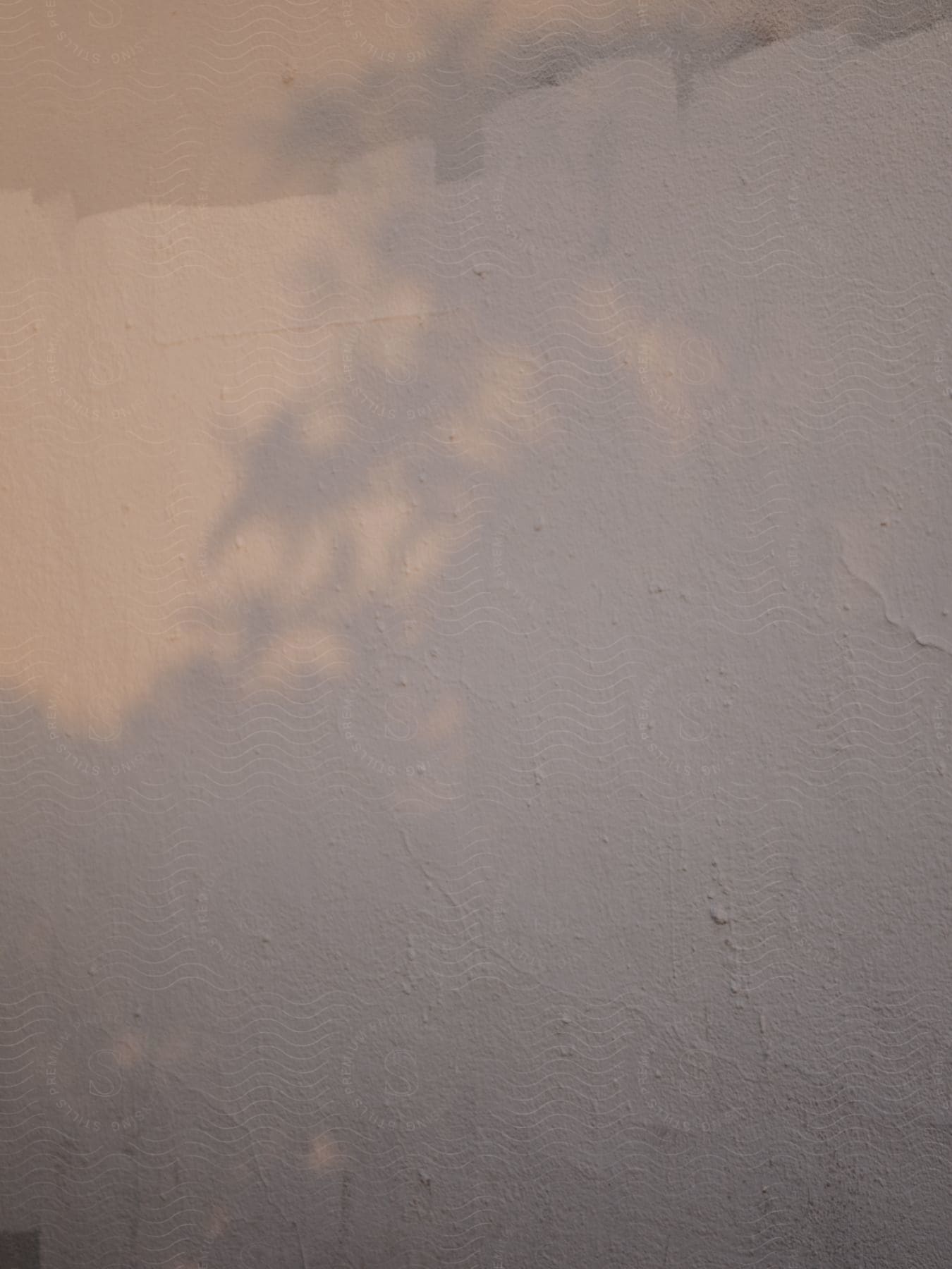 Architecture of a light-toned wall with sunlight reflection.