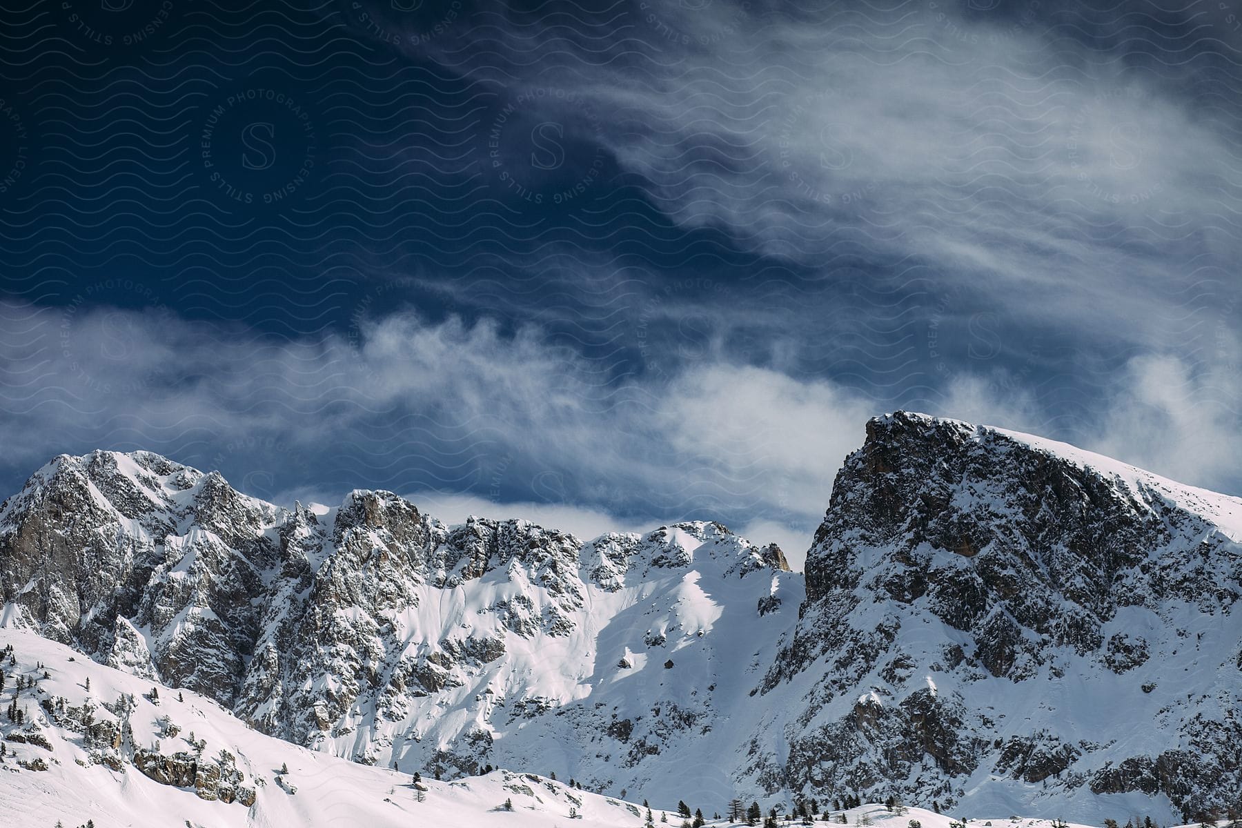 A view of mountains outdoors in the winter, covered in snow.