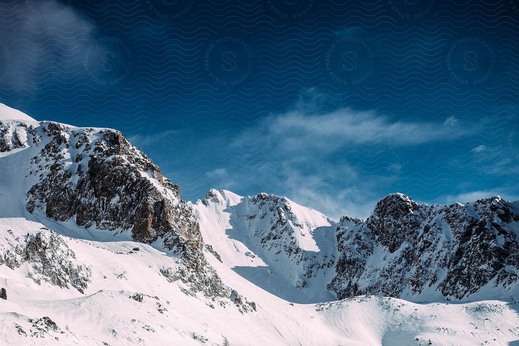 Rocky mountain peaks covered by snow on a sunny day.