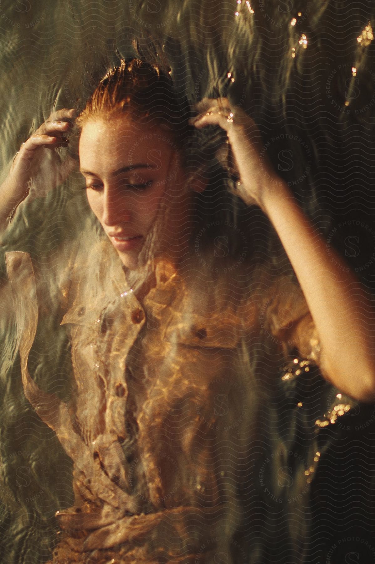 Woman modeling while water falls over her body.