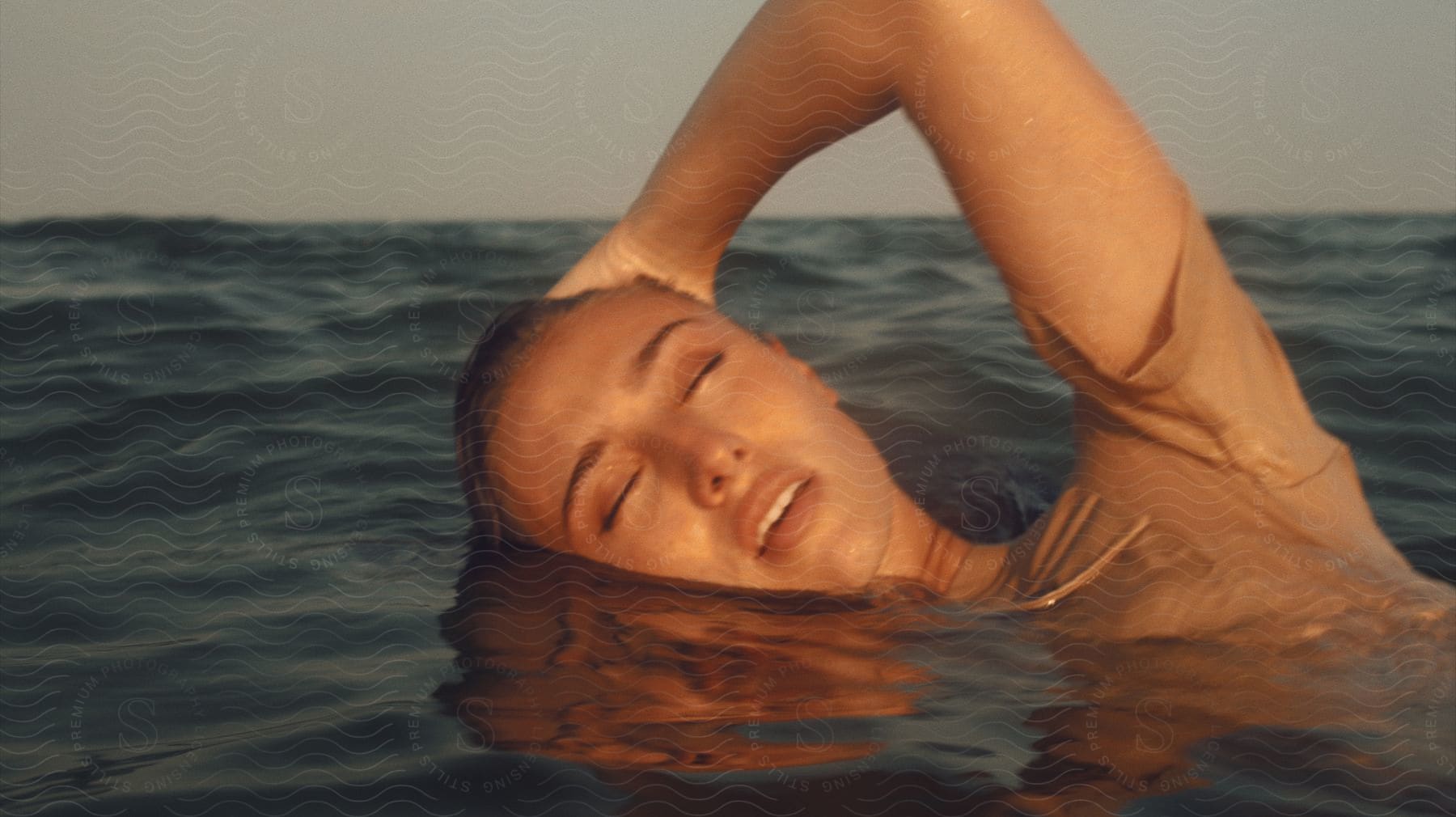 A woman swimming outdoors on a sunny day.