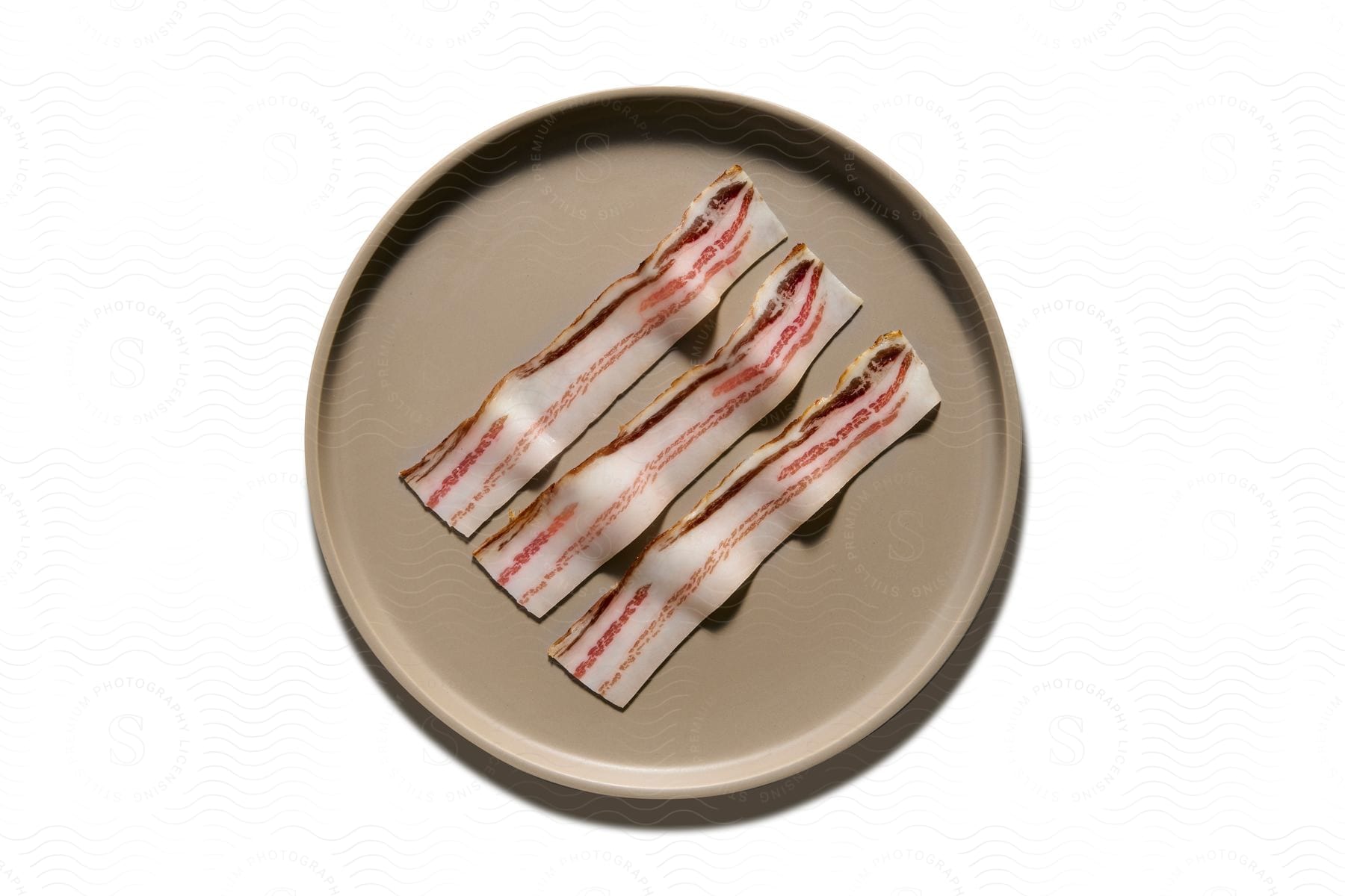 Bacon slices on a plastic plate.