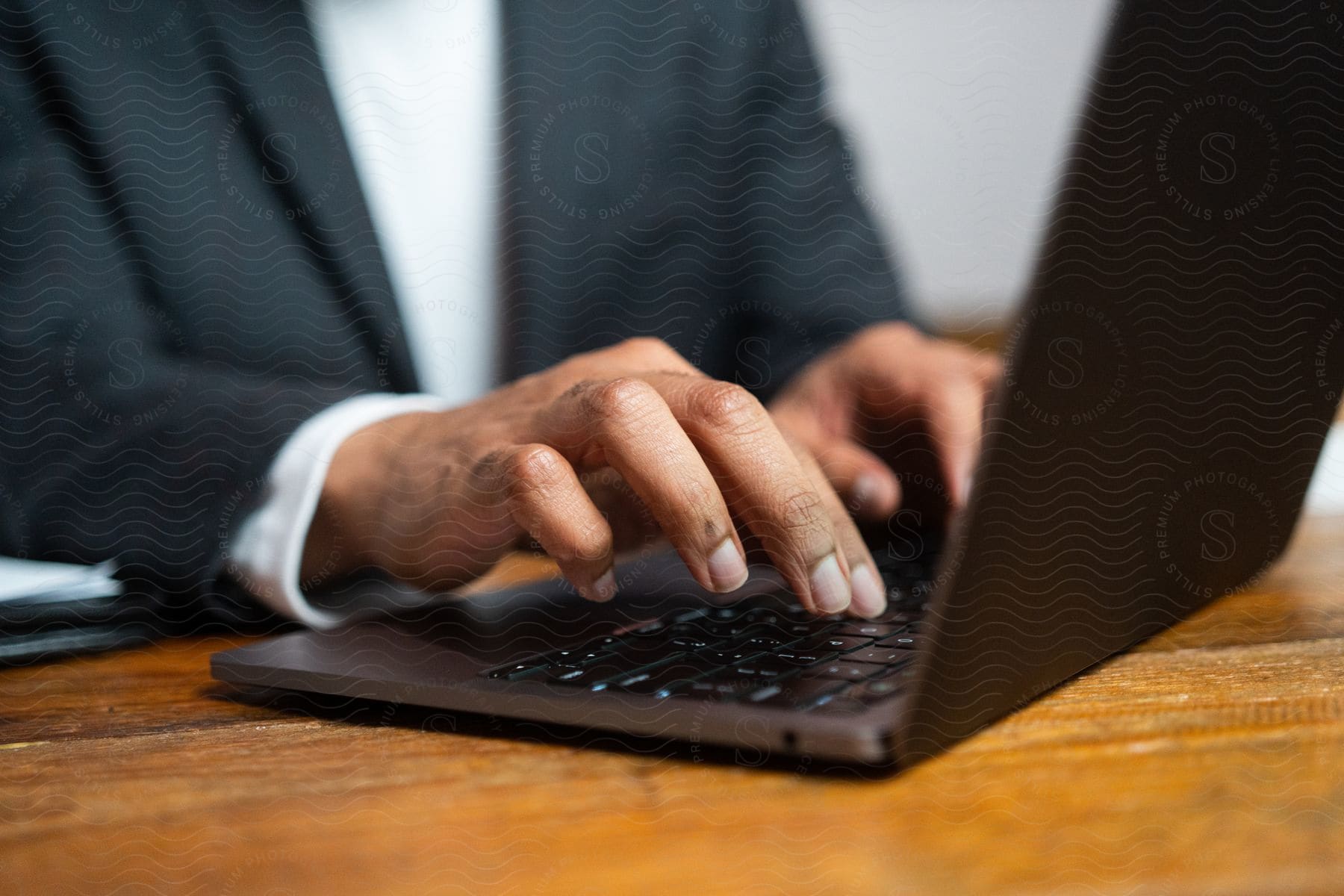 A Man Typing On A Laptop