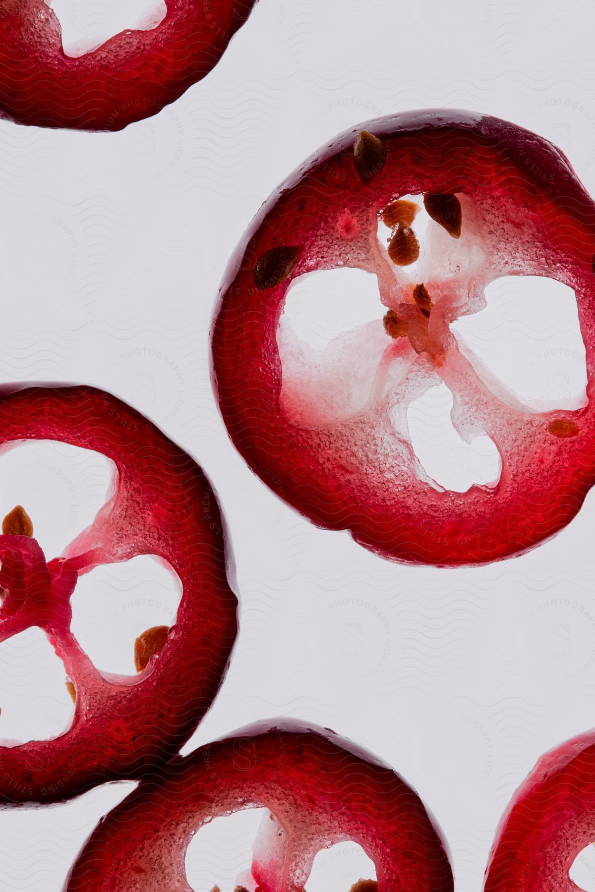 Thin slices of cranberries float in a clear liquid.