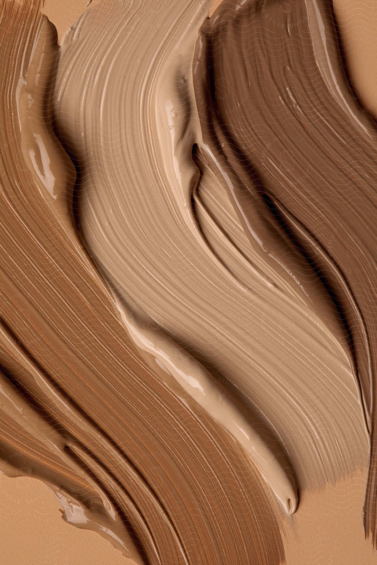 A creamy light brown substance smoothly spread across a brown surface.