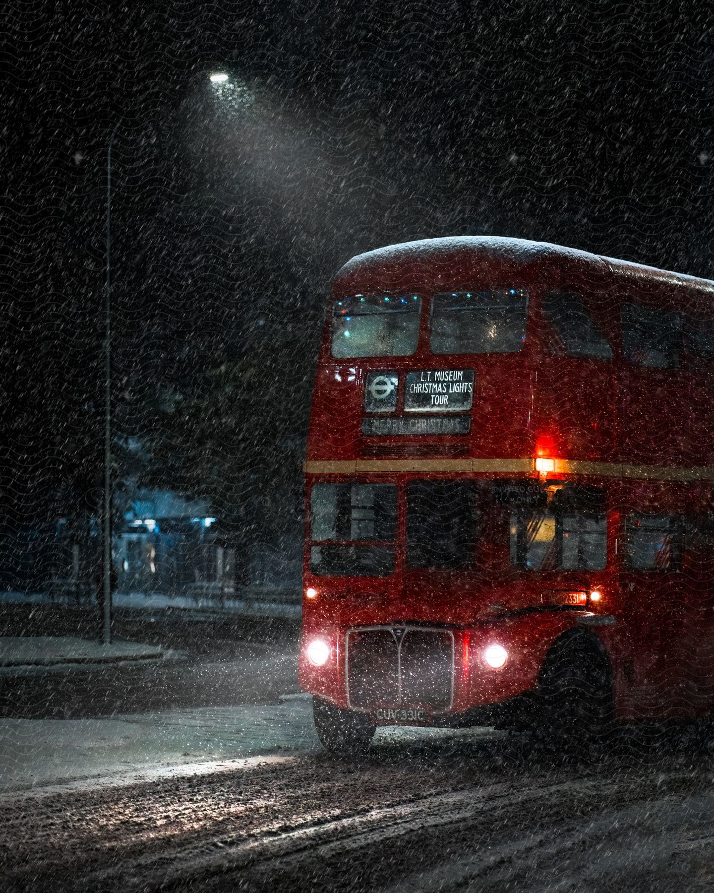 Front of a red public bus on the street on a snowy night