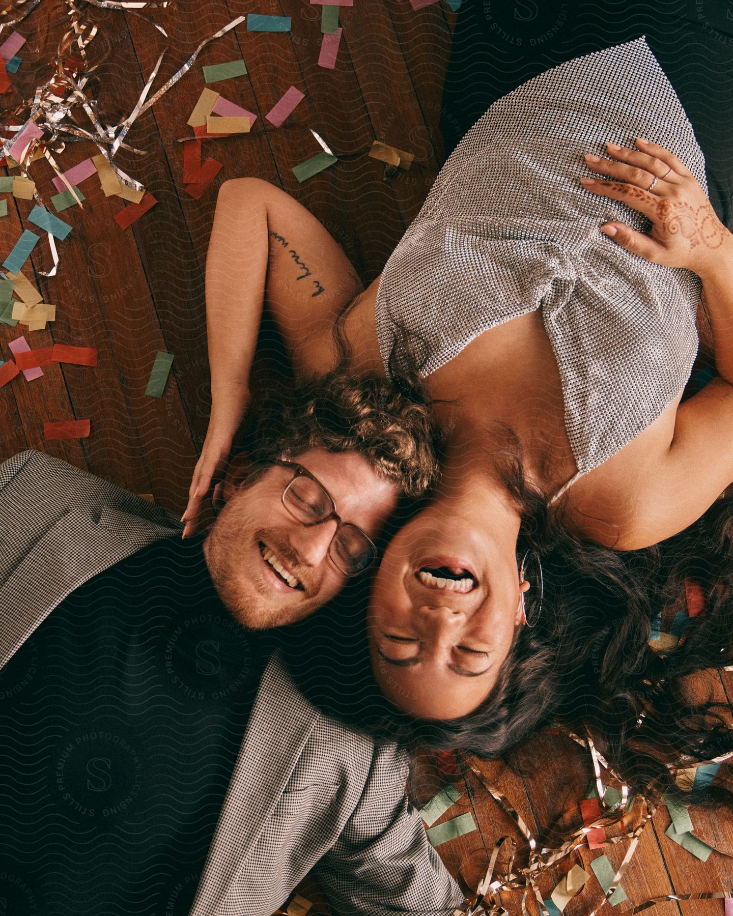 A man and woman laying on the floor laughing