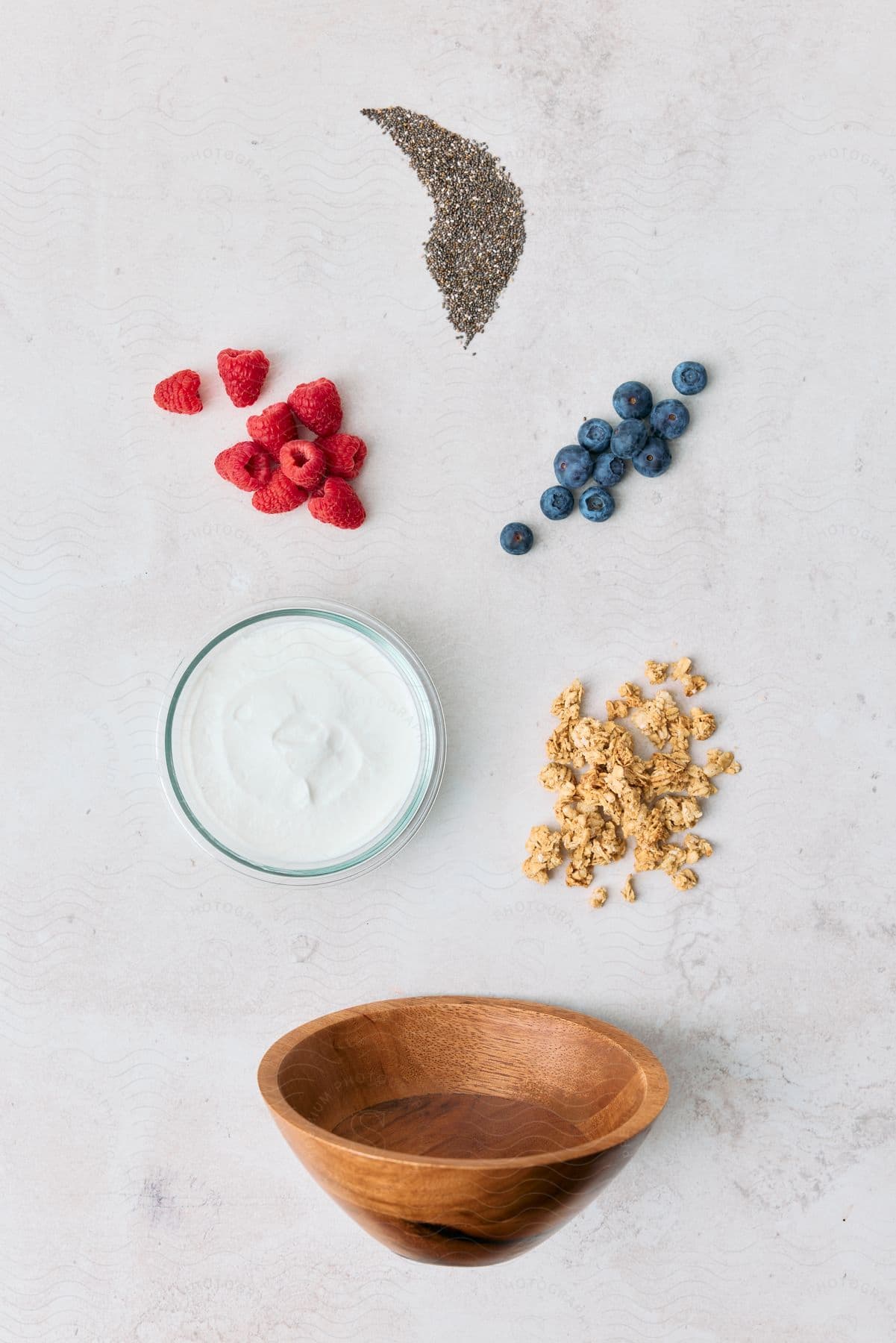 Bowl with yogurt, surrounded by an empty bowl, fruits, and cereals.