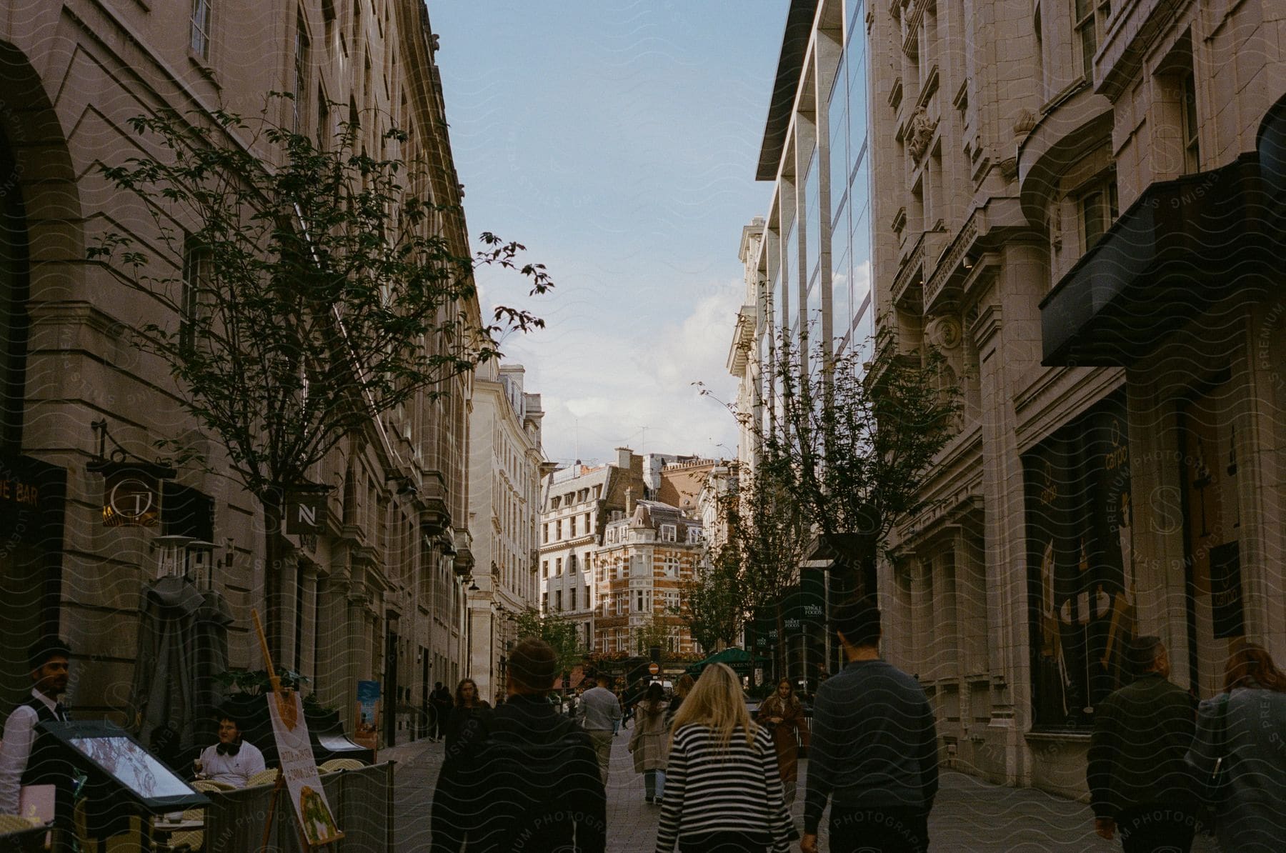 People walking on a pedestrian street in the midst of a city.