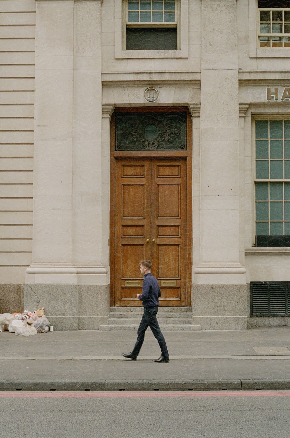 External architecture of a beige building with a large wooden door facing the street.