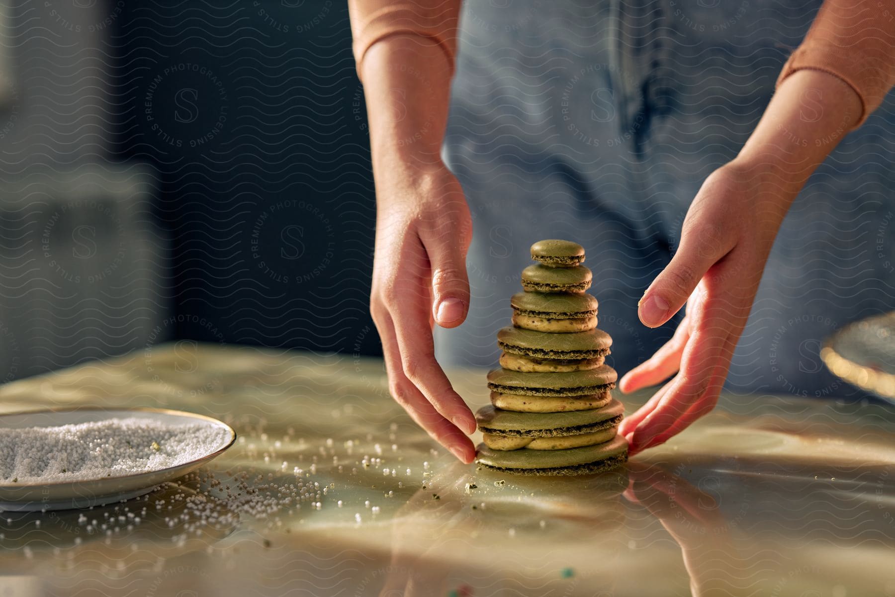 Stock photo of a woman's hands grabbing stacked cookies and cream off of the countertop.