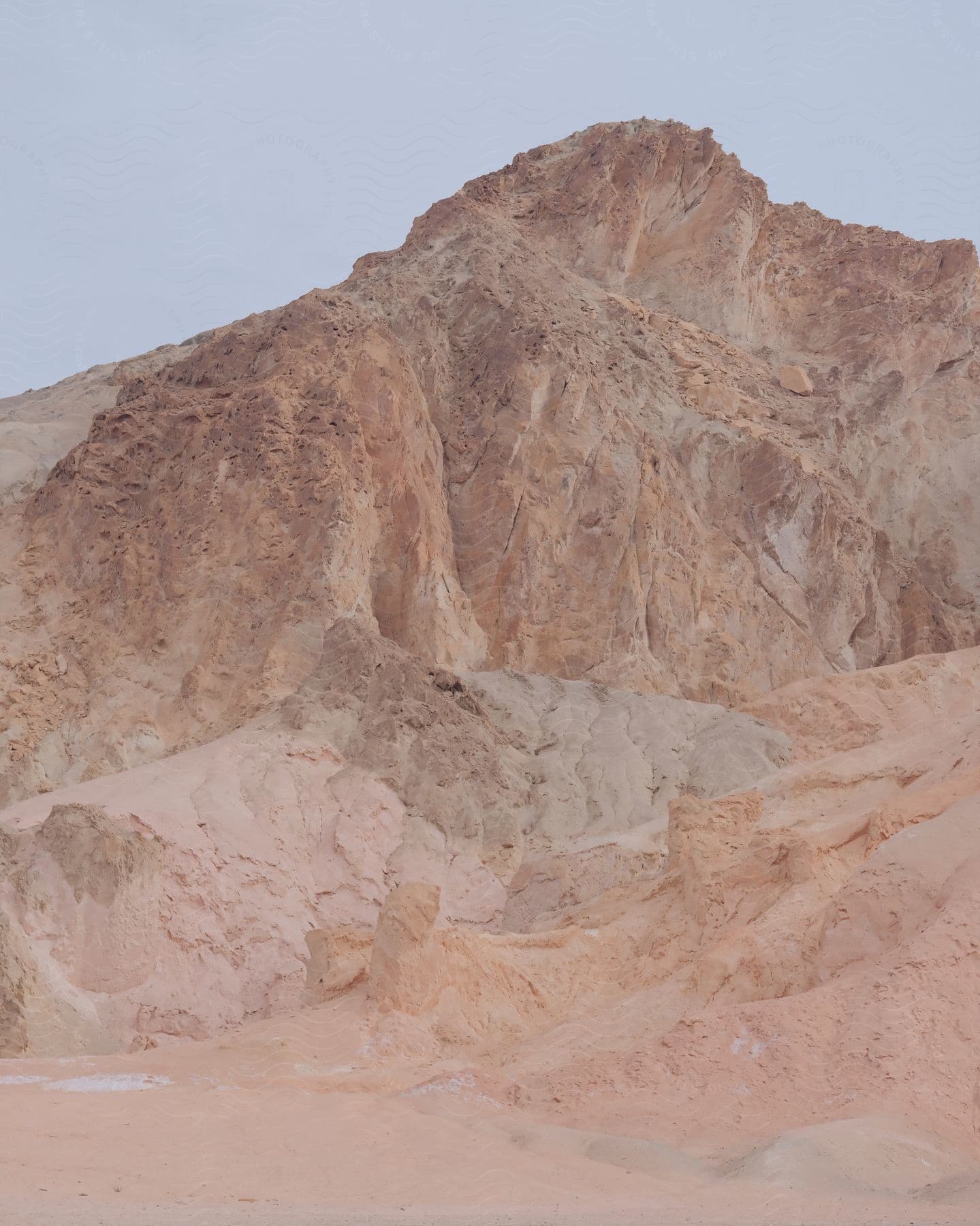 A light brown rocky mountain peak in the desert.