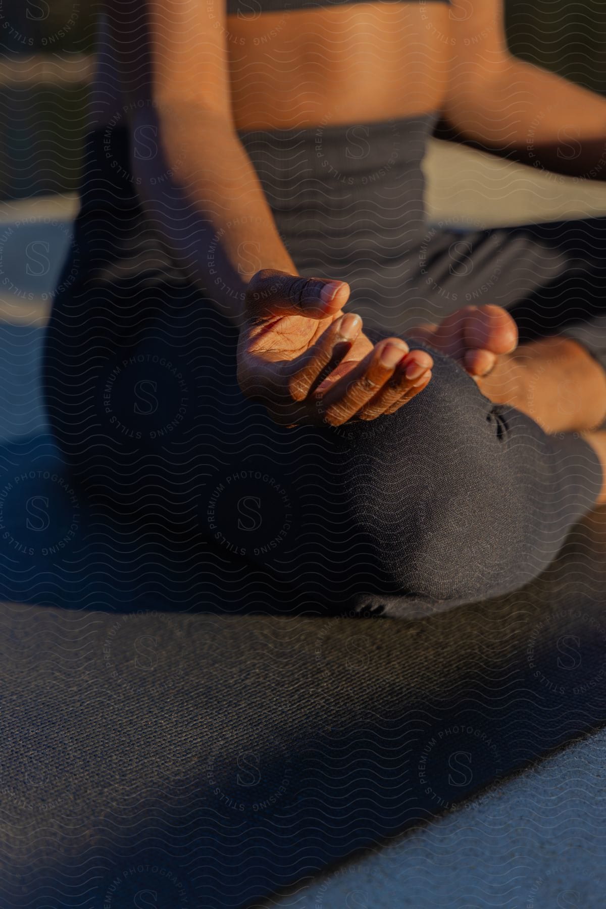 A Woman Rests Her Hand On Her Knee As She Sits And Meditates