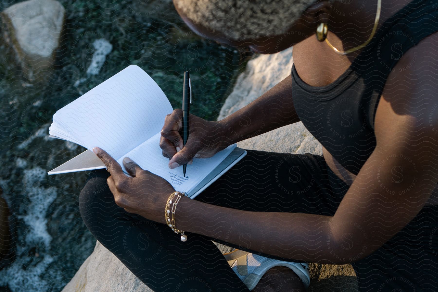 A woman writes a poem in a notebook.