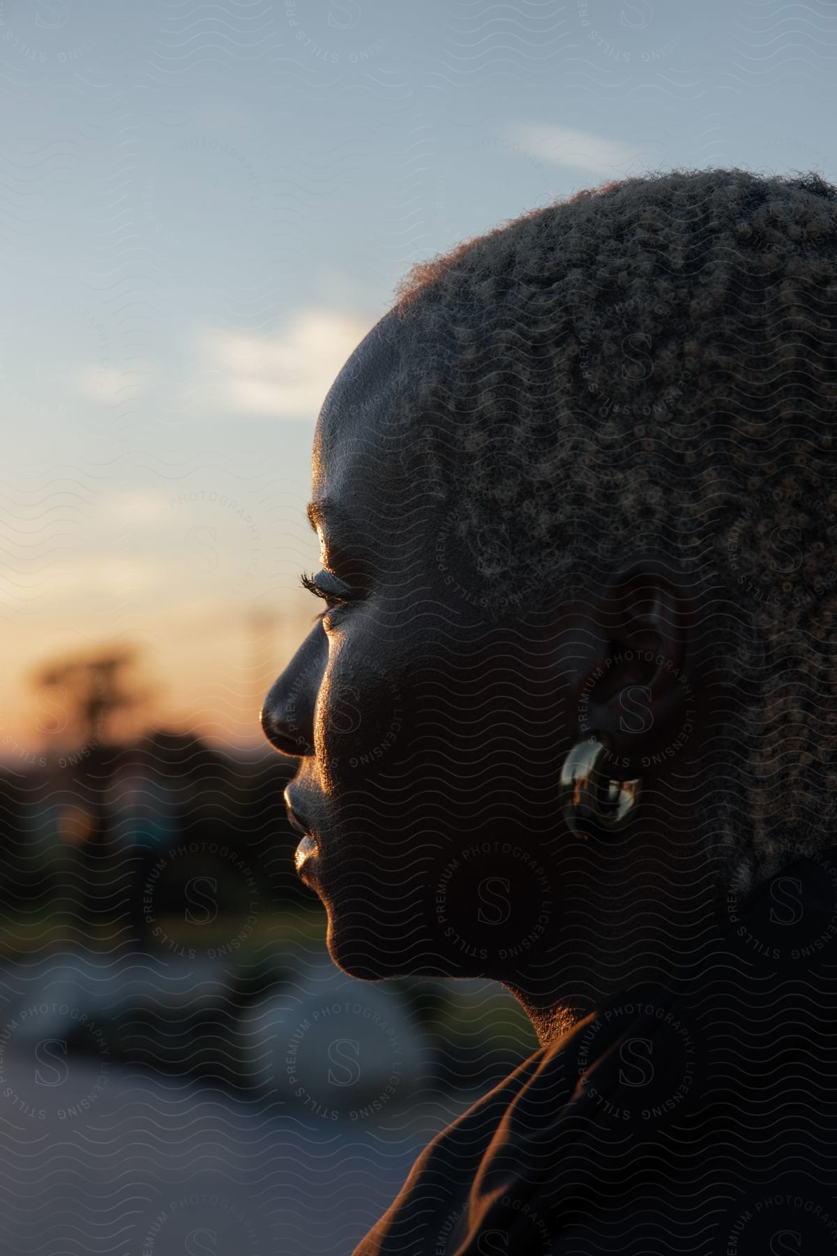 A portrait of a woman outdoors at sunset.