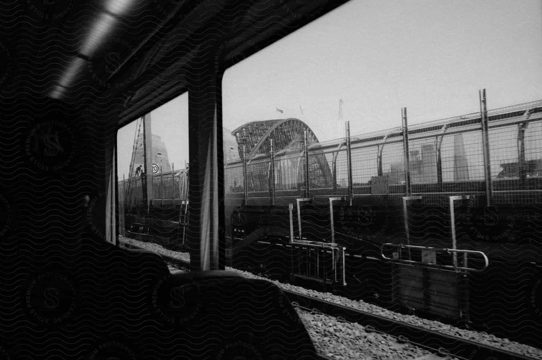 Looking out of a train at a bridge with skyscrapers in the distance.