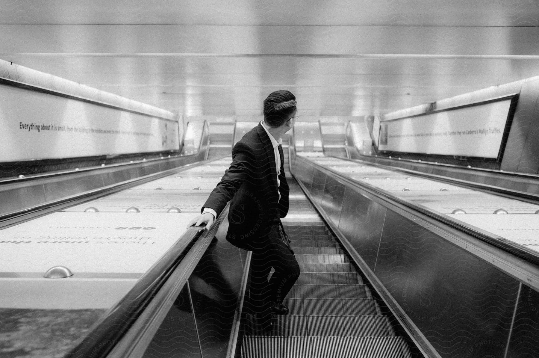 a man on suit riding on an escalator