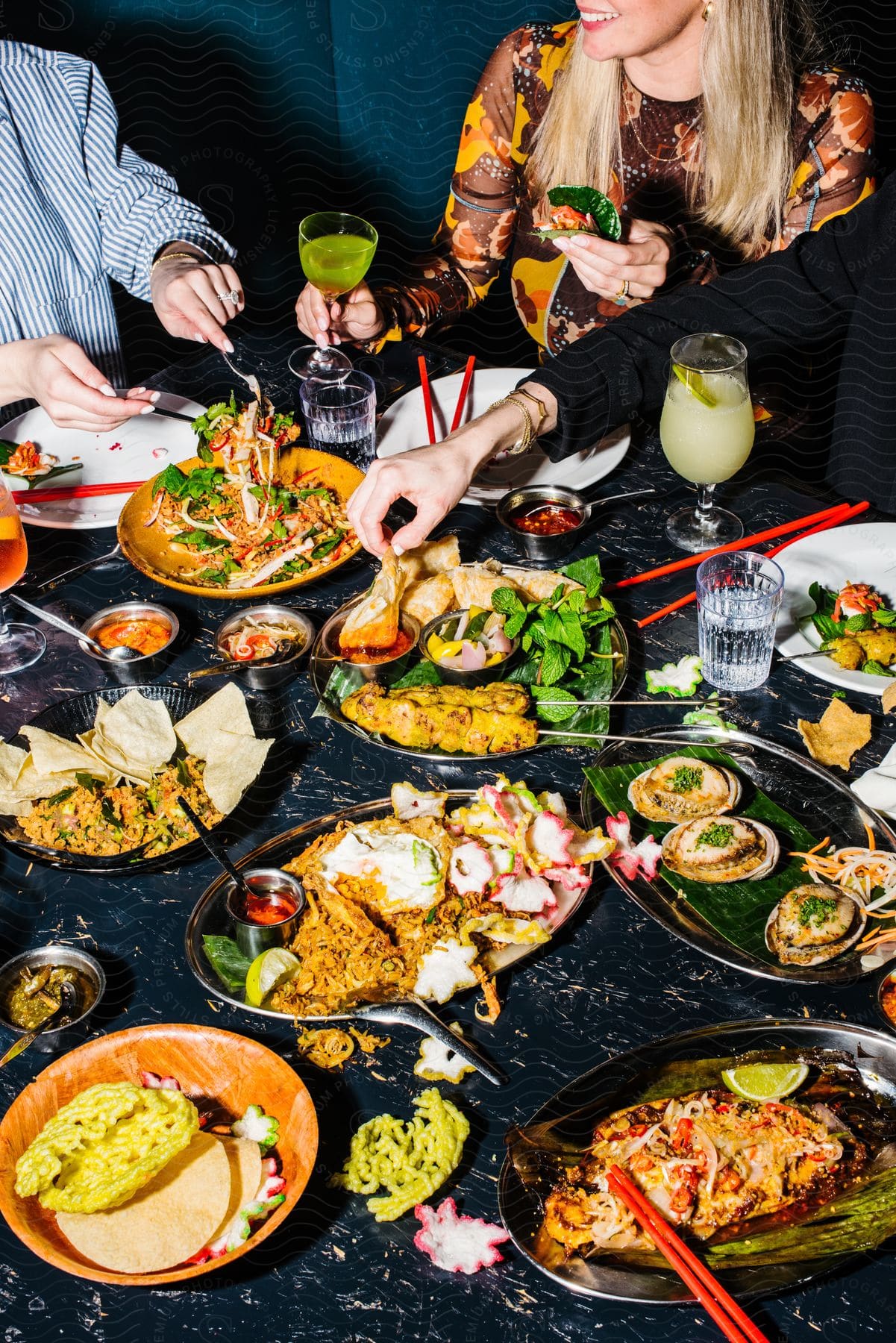 Presentation of a table with dishes and people sitting around.