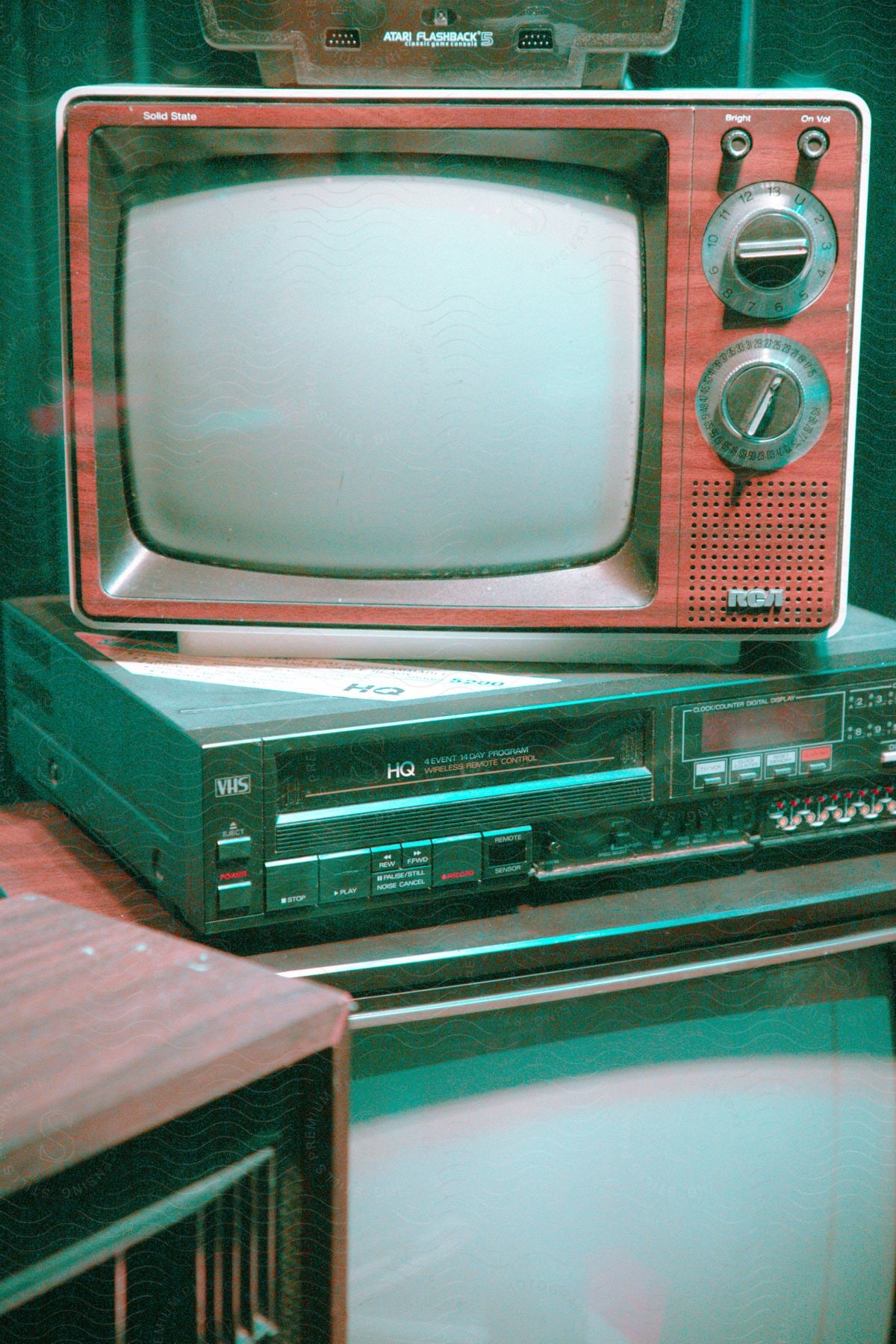 An old television and a VCR are stacked on top of each other.