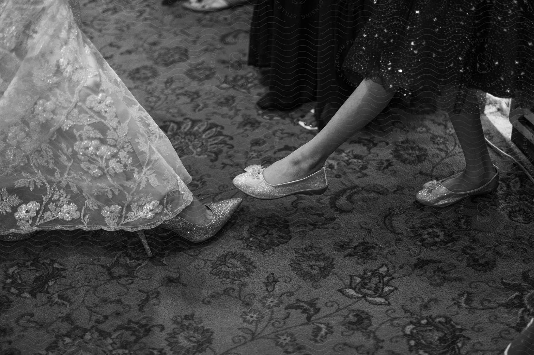 Two women posing and showing their shoes.