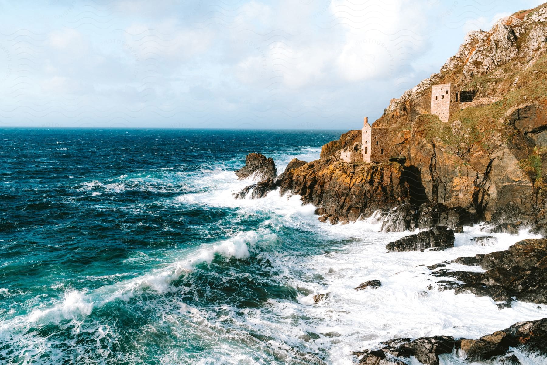 The Botallack tin mine engine houses are perched on the cliffs, a historic and picturesque sight against the coastal landscape.