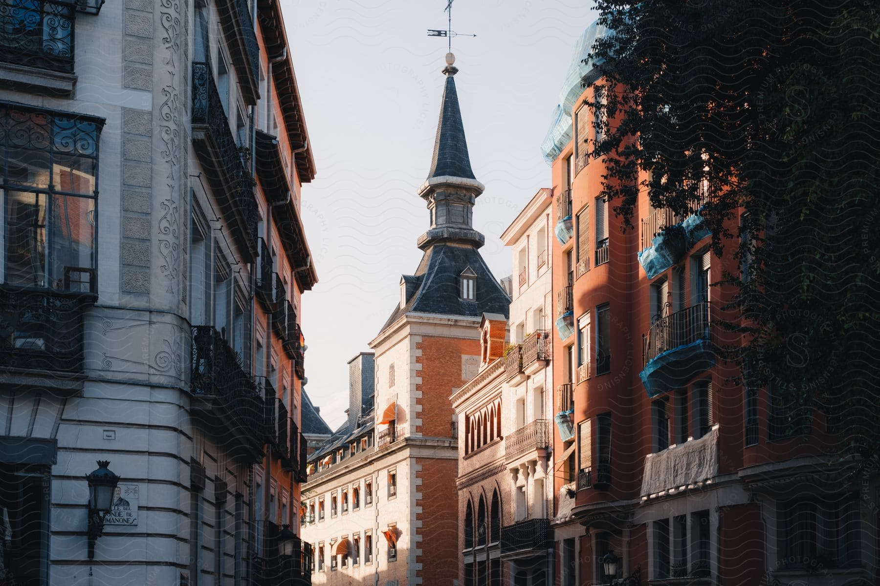 An ancient church tower seen down a European city street.