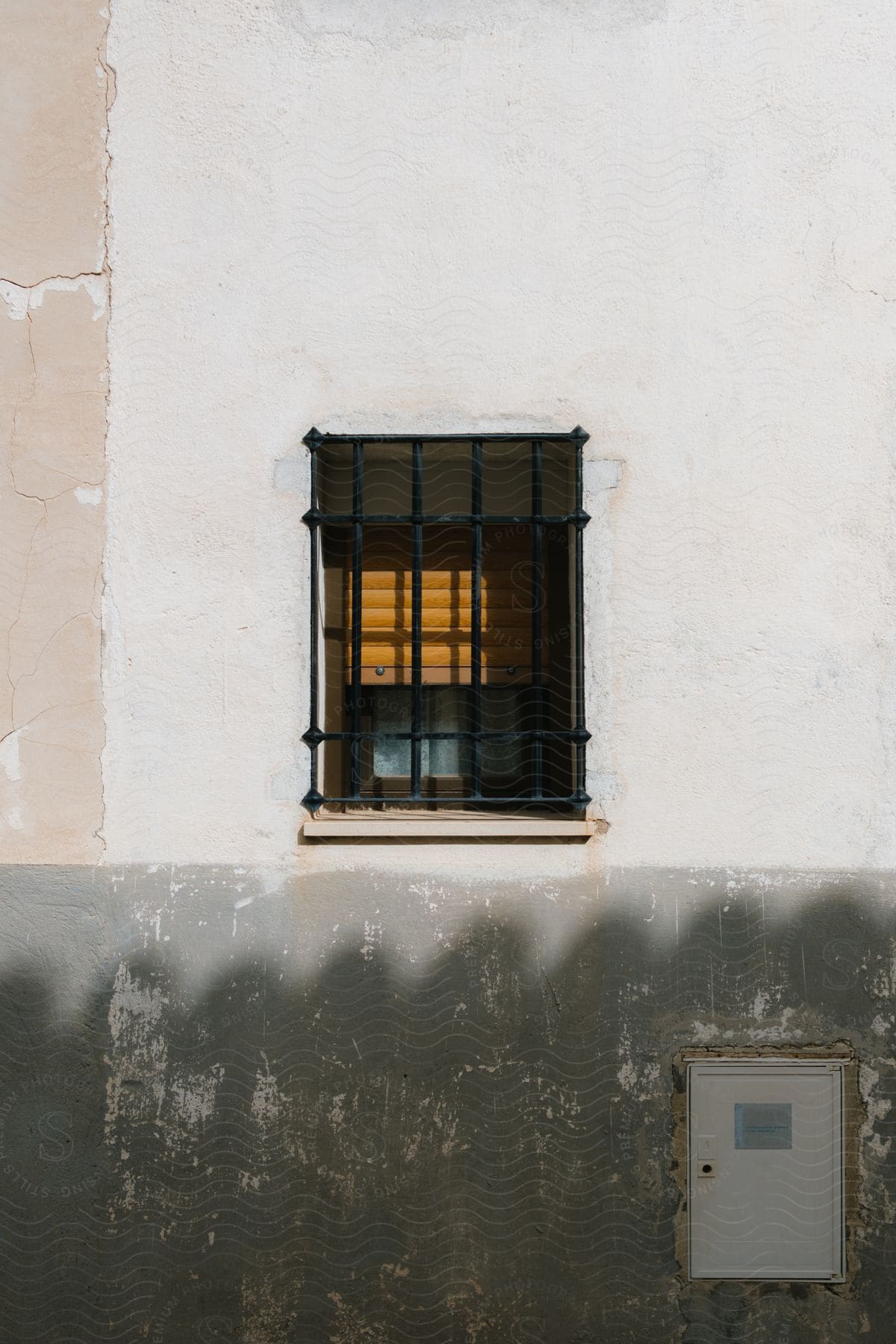 View of an external window with a black grille on a white wall.