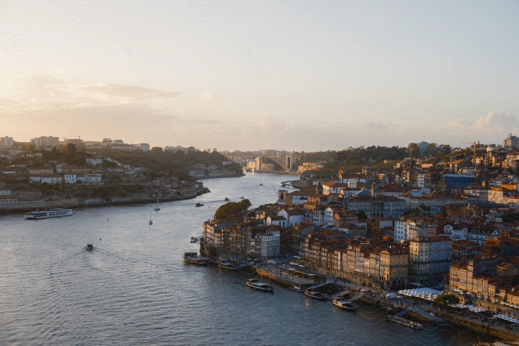 Boats move down the river with buildings on both sides.