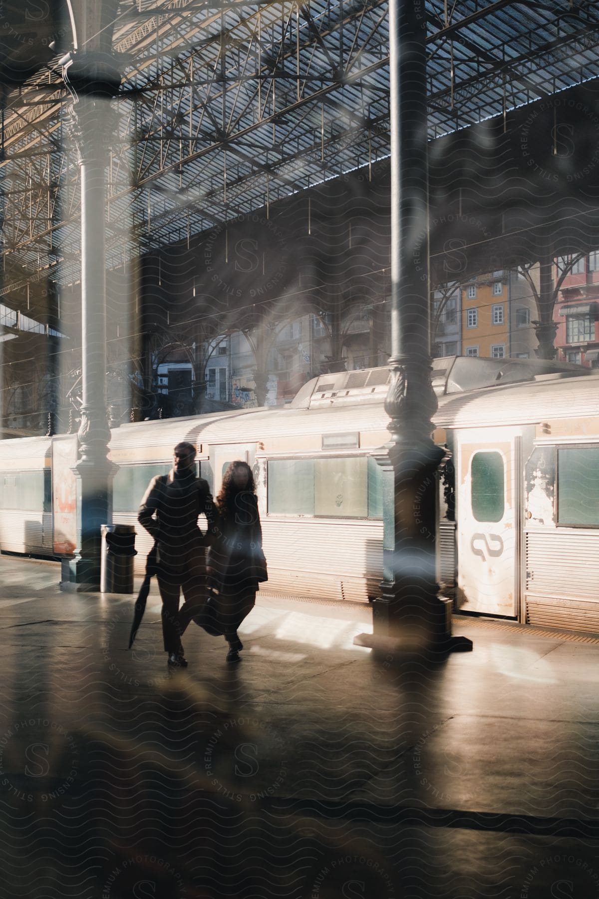 A Man And A Woman Walking On The Platform Near A Subway