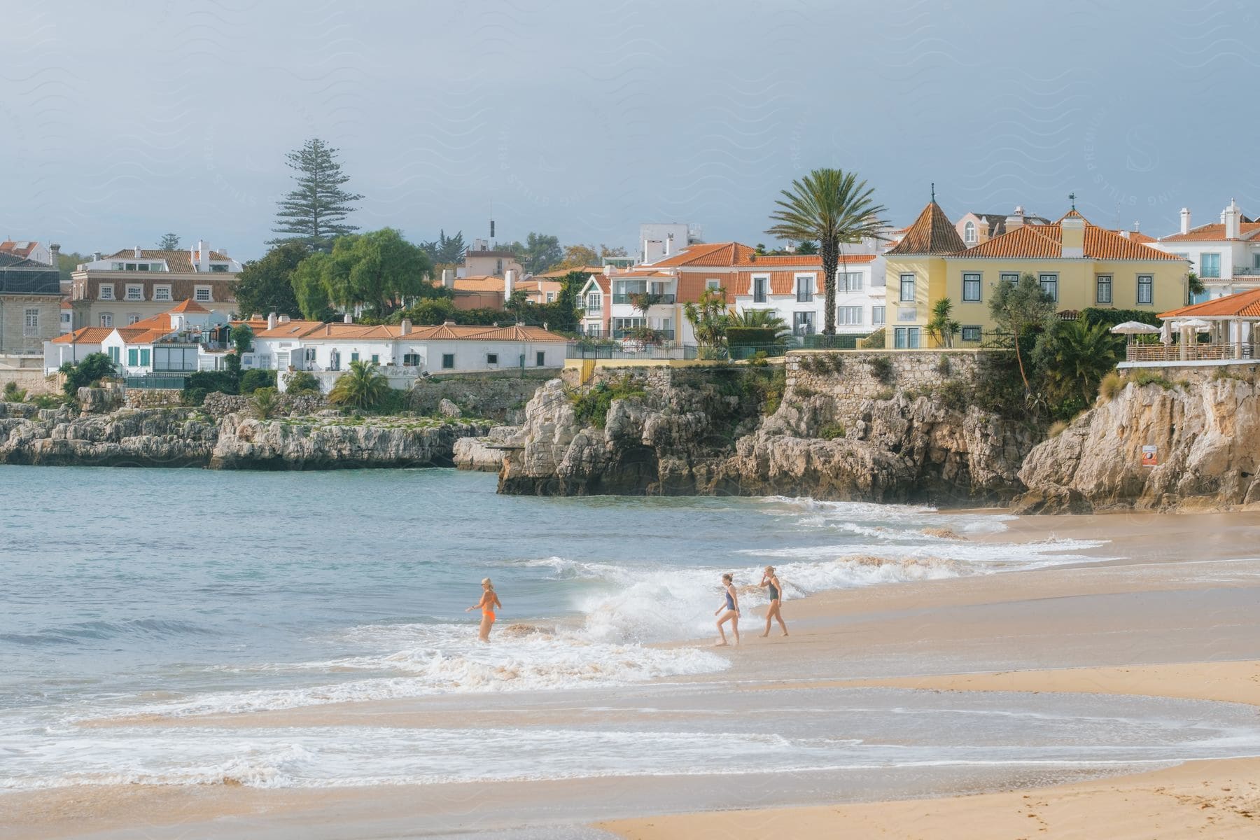 Friends have fun in the beach next to a coastal town