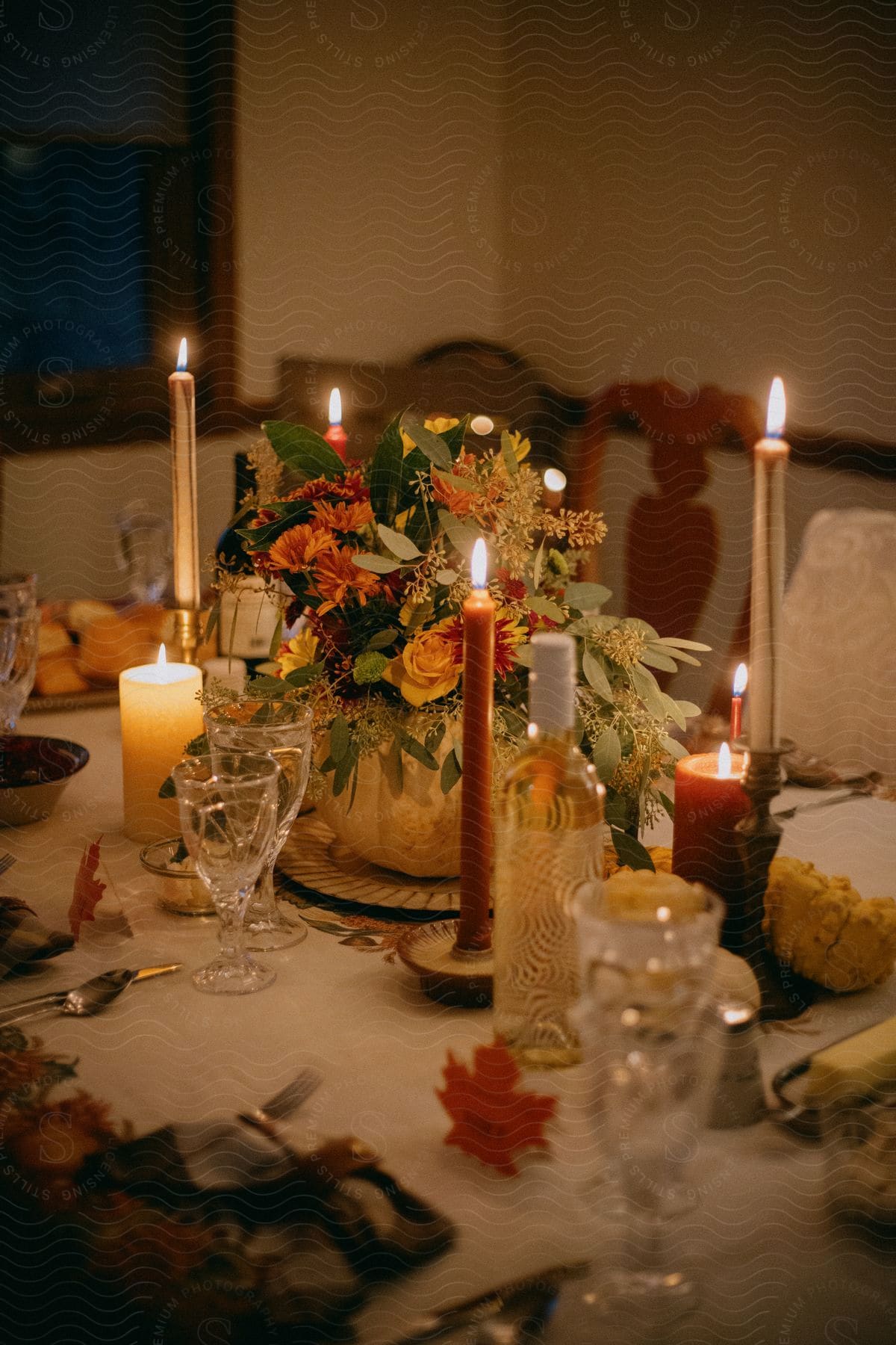 food, drinks, and lit candles on a dining table at night