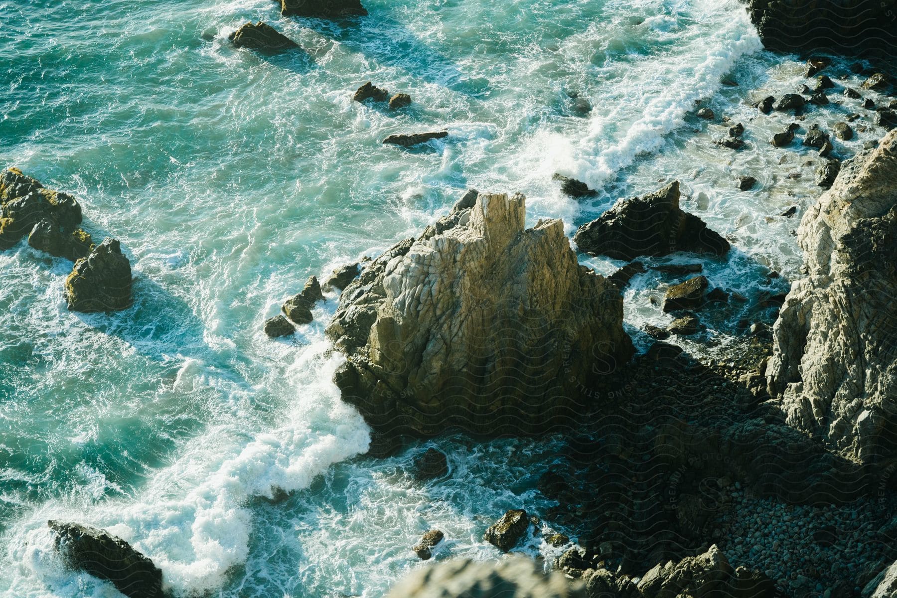 An Aerial View Capturing The Rugged Beauty Of A Rocky Coast, Where Land Meets The Untamed Waves Of The Sea