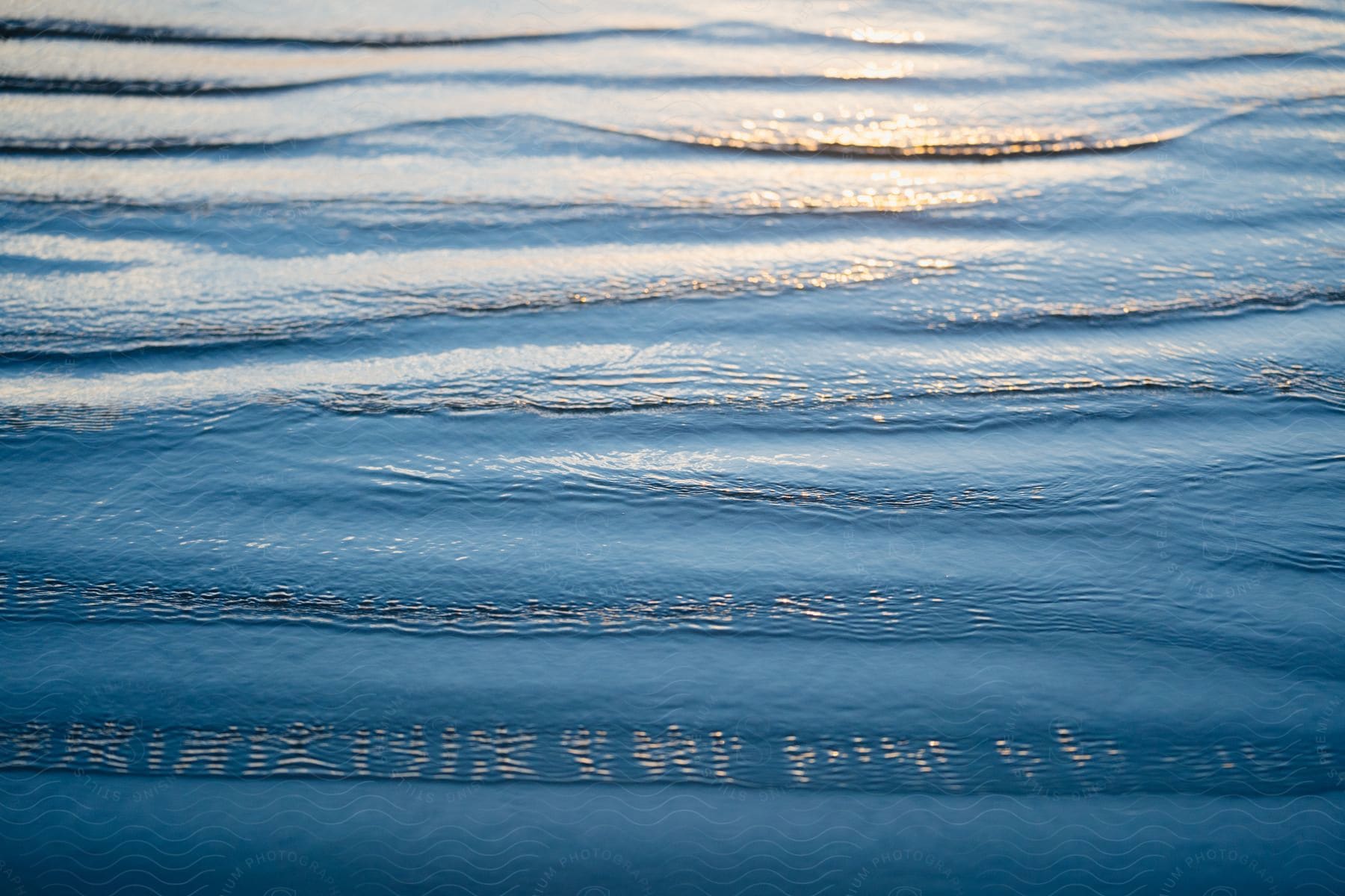 A Body Of Blue Water, Its Surface Adorned With Gentle Ripples