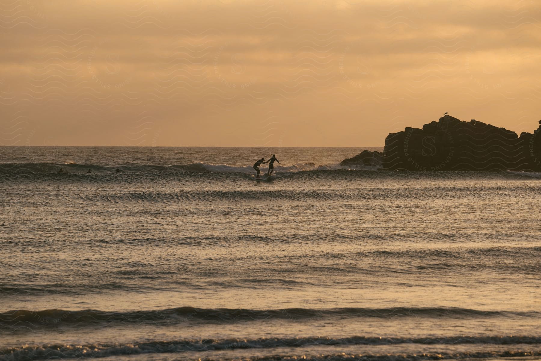 Two surfers riding a wave side by side.