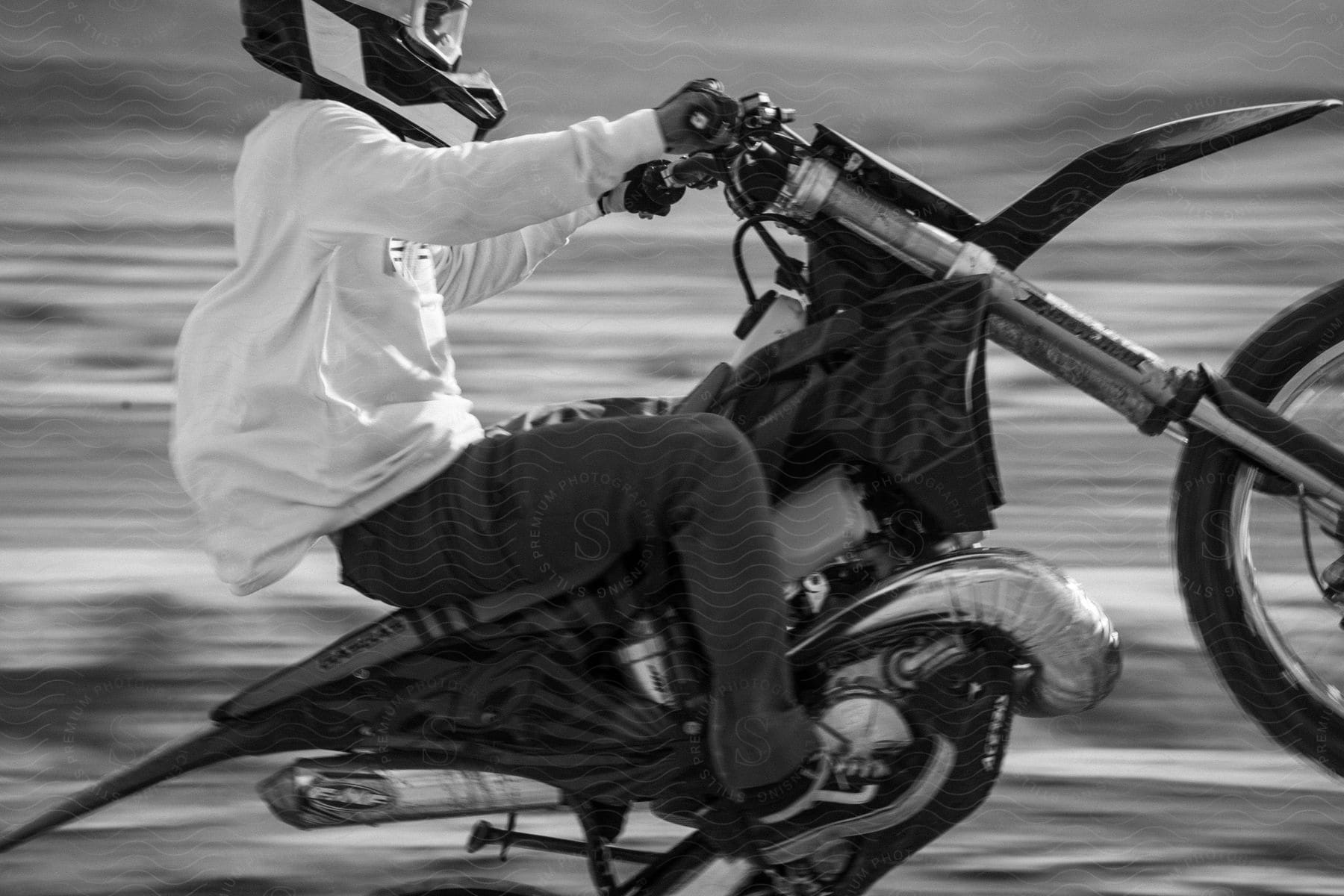 a biker wearing a white shirt and helmet while riding a dirt bike