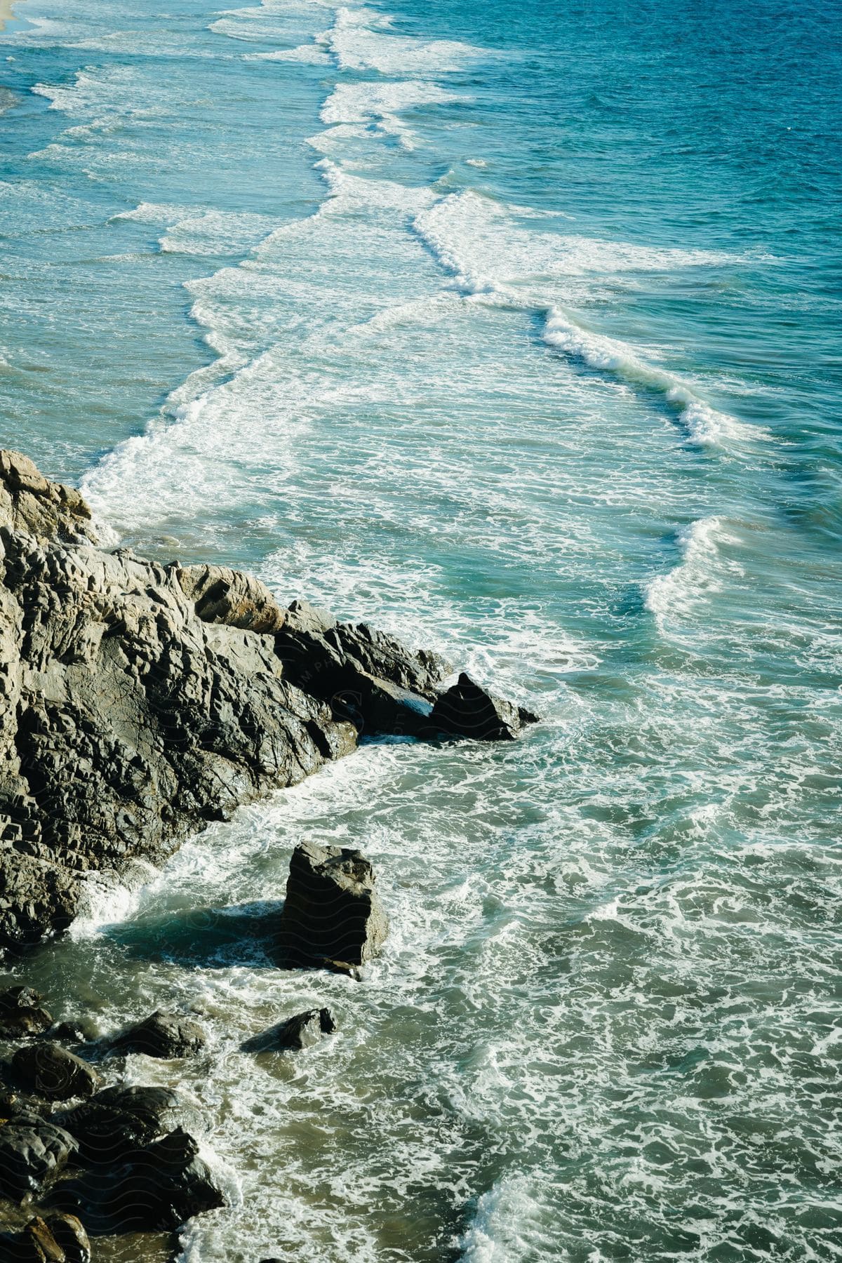 A view of some waves in the ocean crashing against rocks.