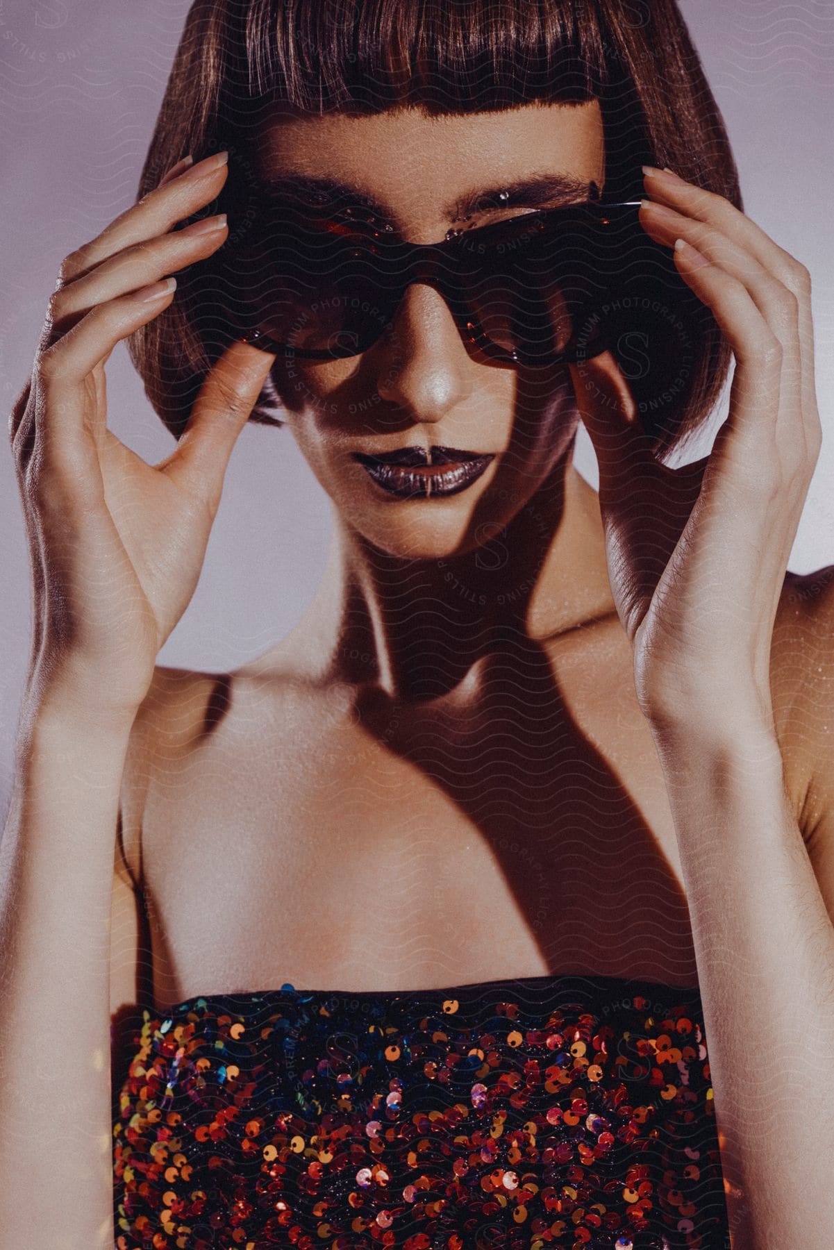 Stock photo of a woman modeling some sunglasses and a dress.