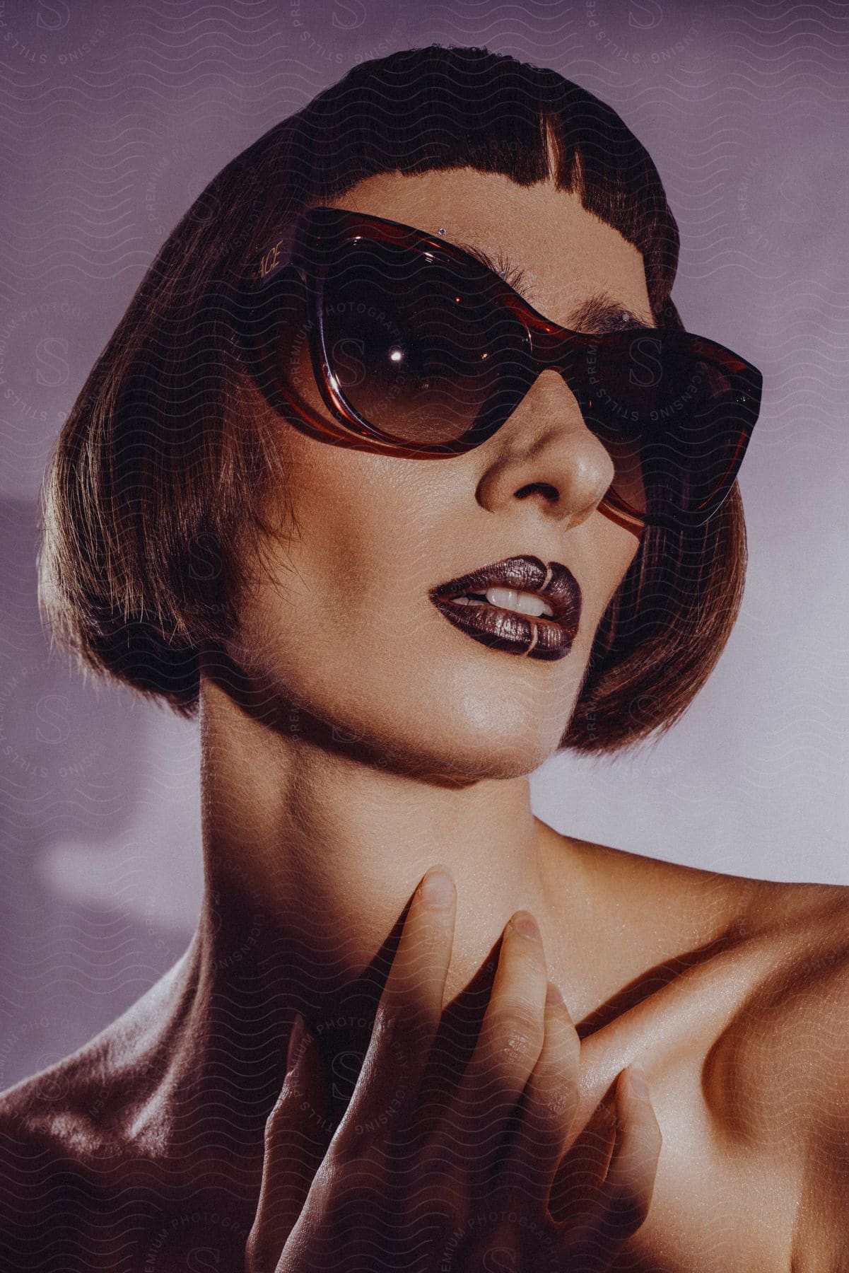 Close up of a female model with a bob haircut, earrings, sunglasses and dark lipstick