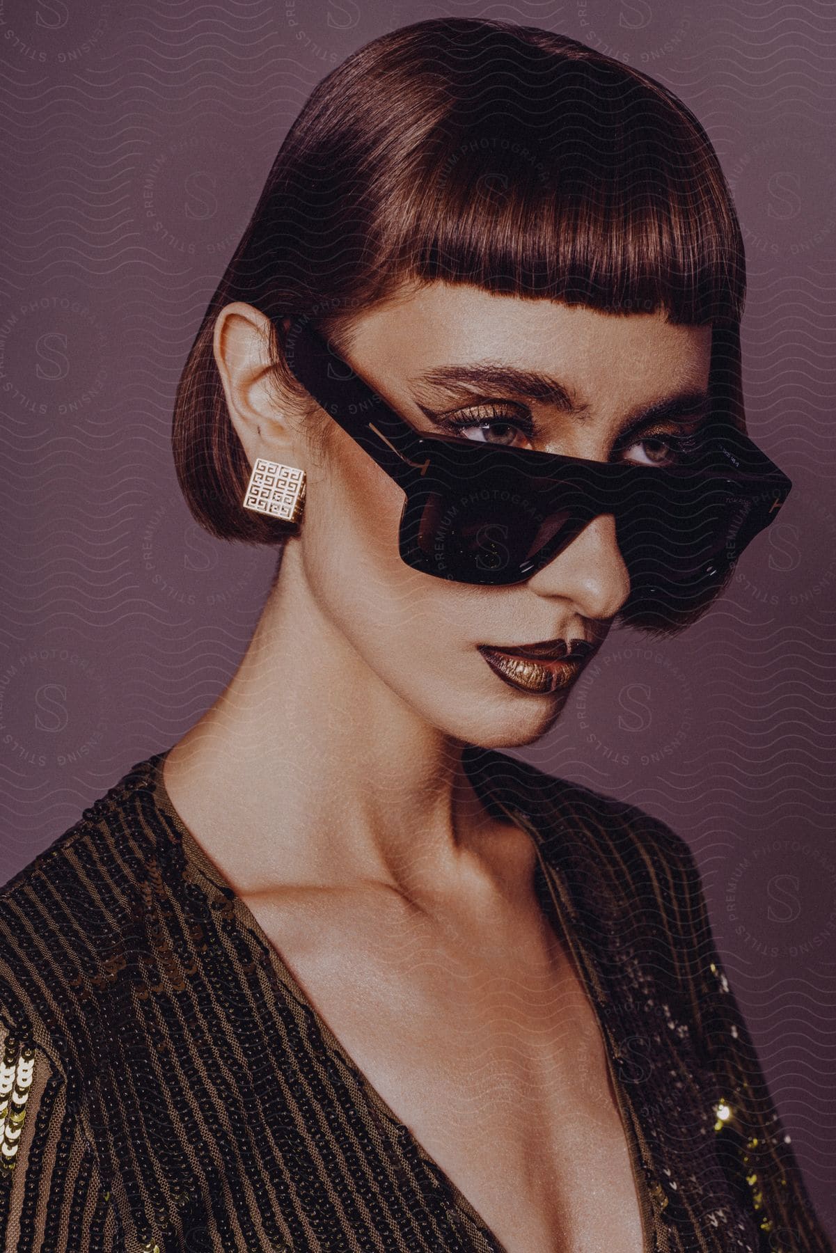 Woman with square sunglasses, earrings, and a sequined dress.