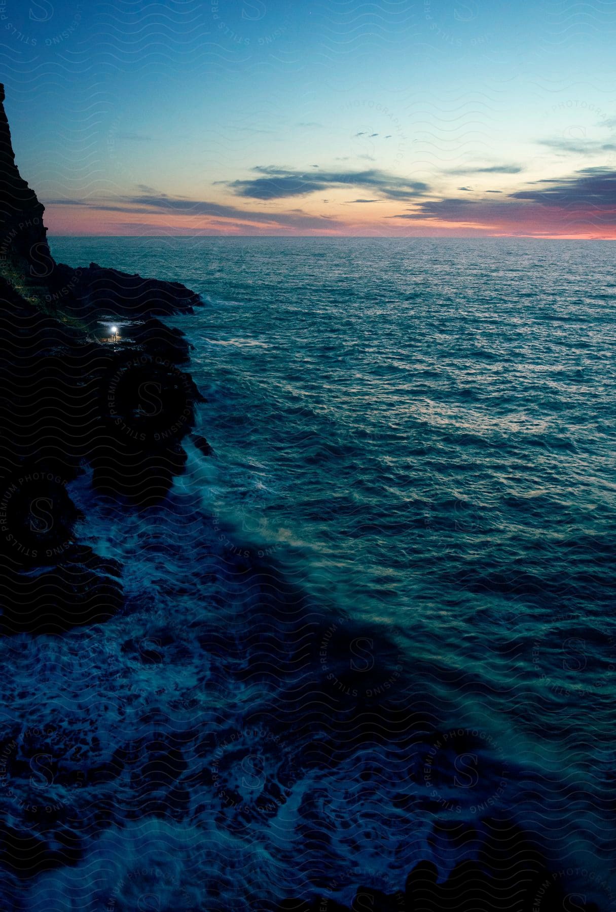 A view of the ocean along the edge of the coast with cliffs.