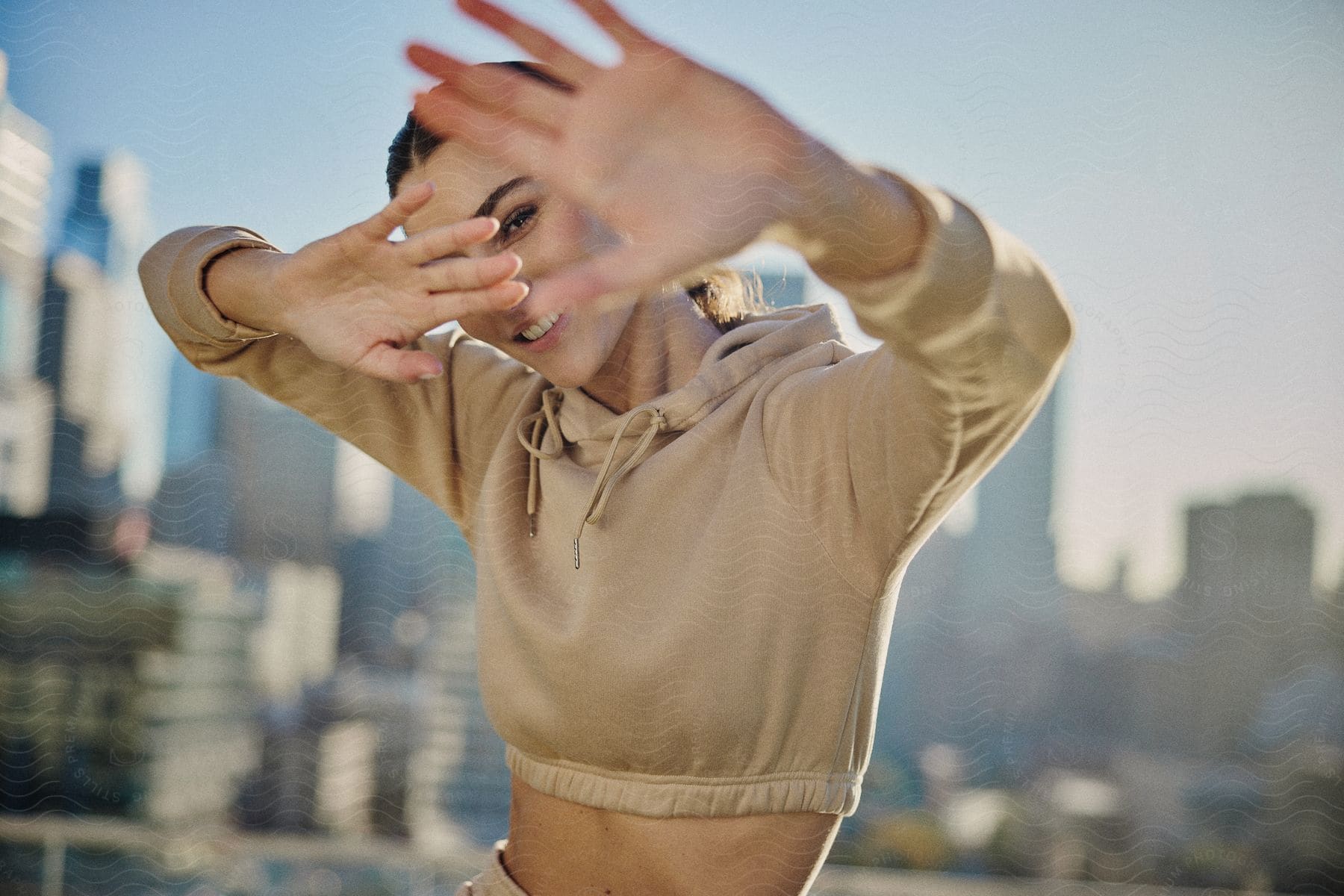 Stock photo of a female model playfully hiding her face from a candid photo.