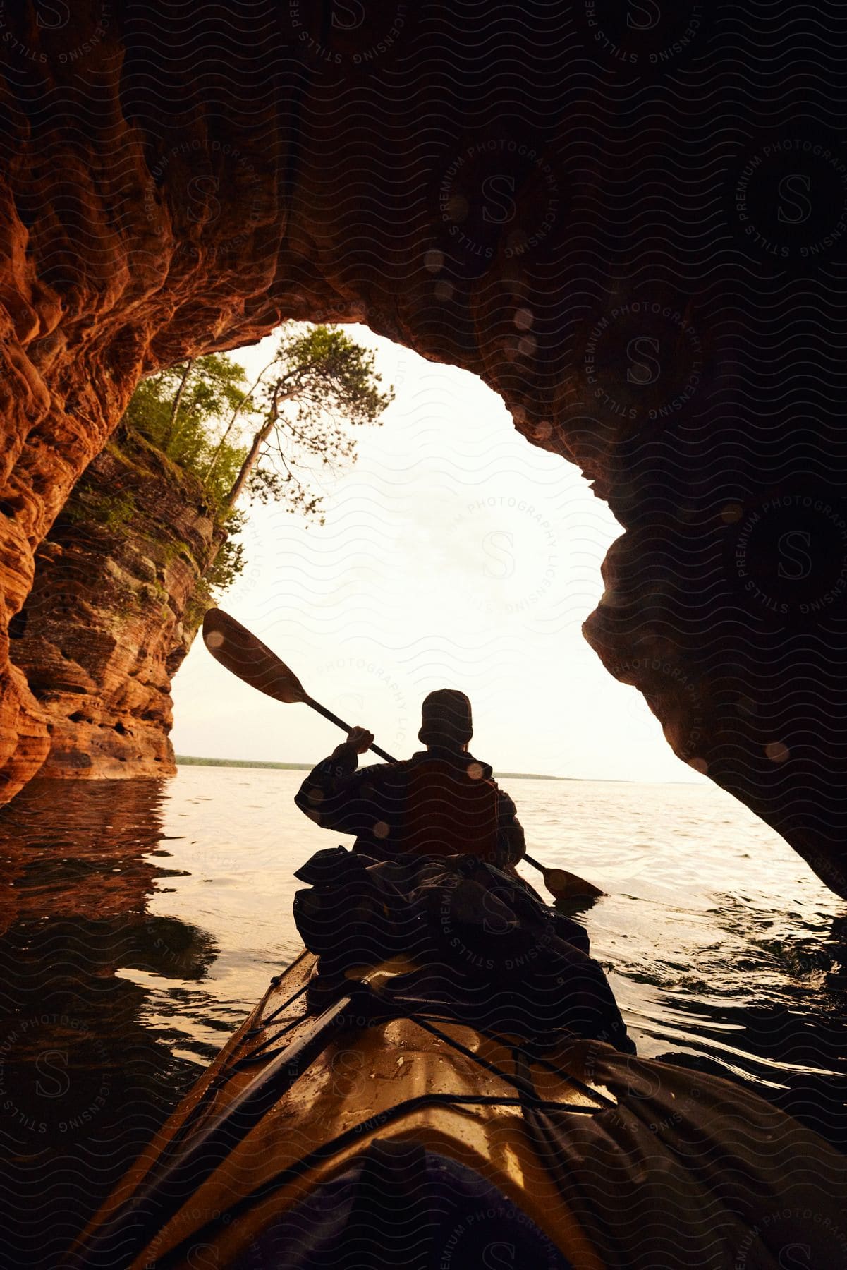 a person riding a canoe out from a cave