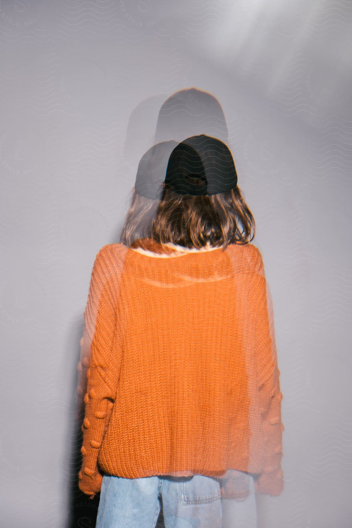 A woman modeling in an orange sweater