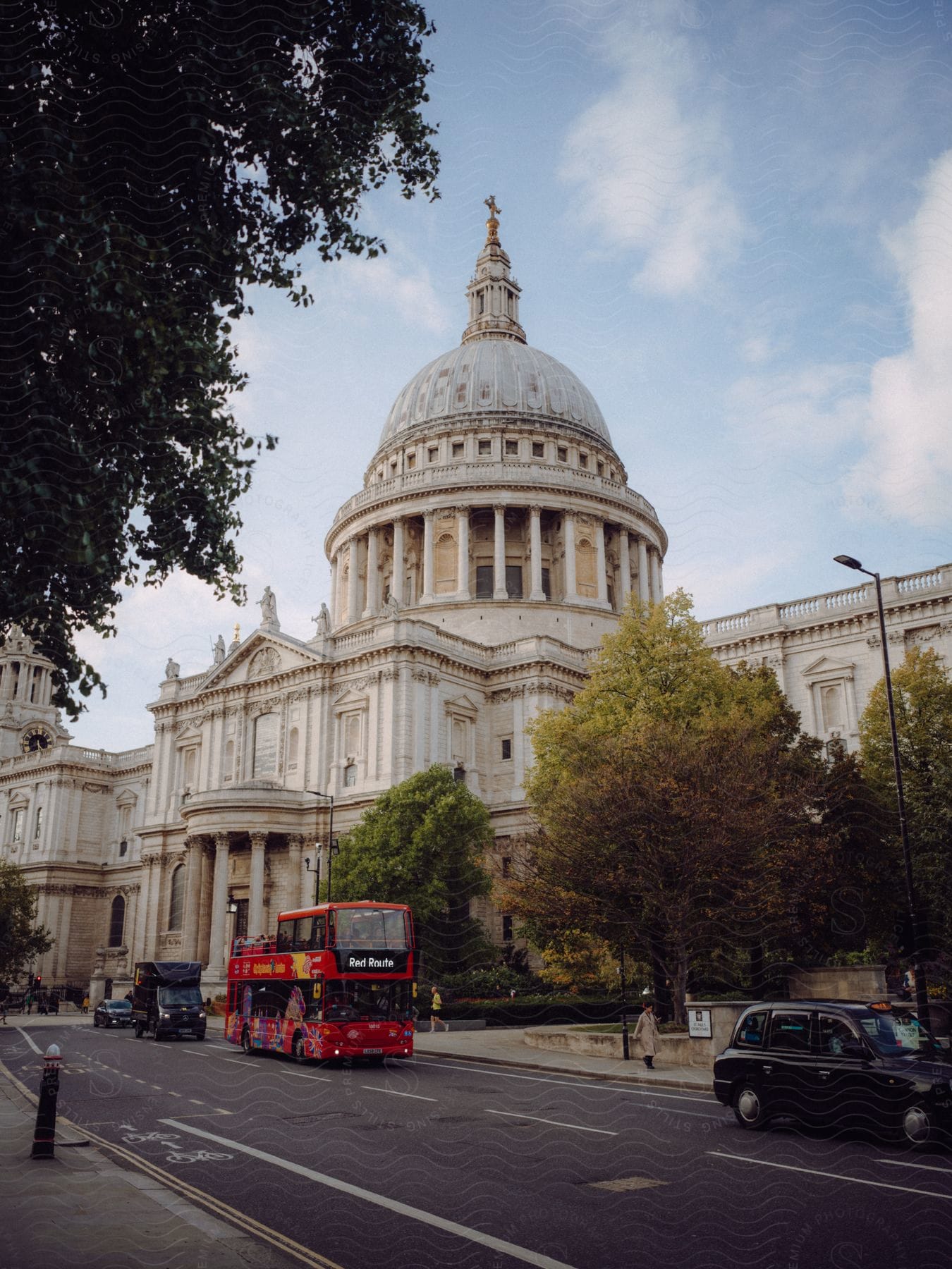 Tourists on a double decker bus traveling past St Paul's Cathedral in London