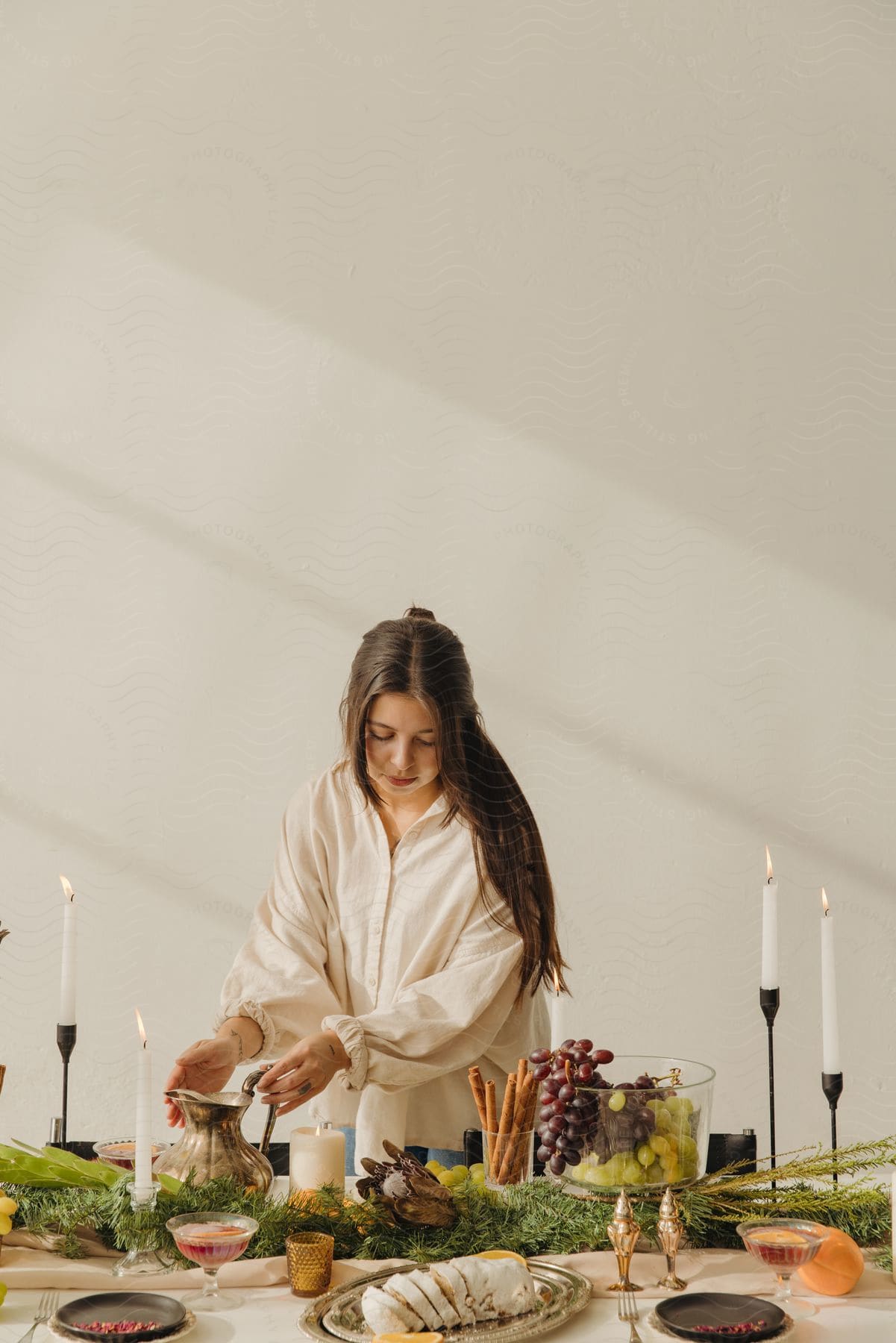 A woman is setting a table that is full of food