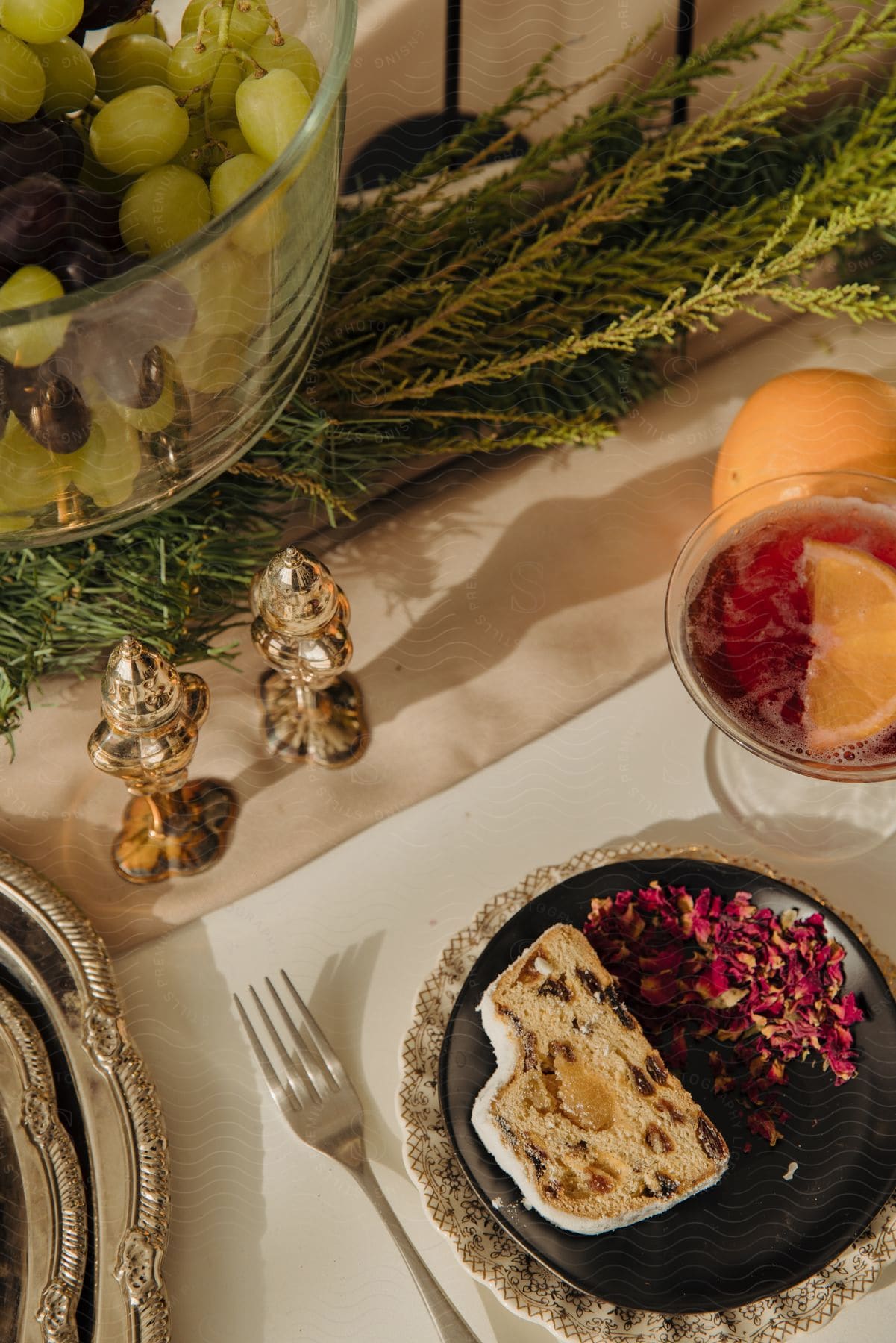 A decadent dessert plate in a fancy restaurant: frosted nut bread, fruit medley, and an martini with an orange twist.