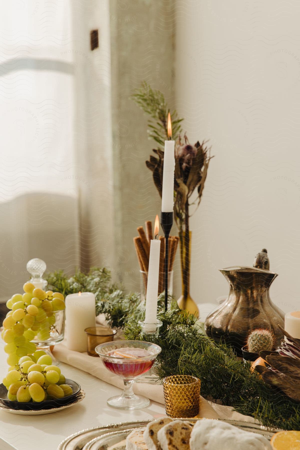 winter tablescape with candles, evergreen garland, grapes