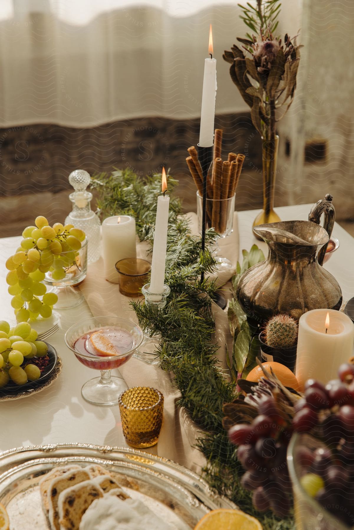 Winter Tablescape With Candles, Evergreen Garland, Glassware And Grapes