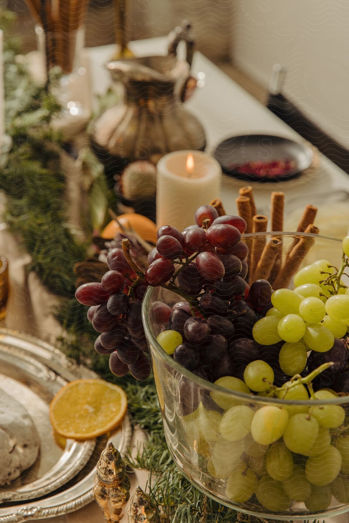 a bowl of grapes and cinnamon sticks on a table.